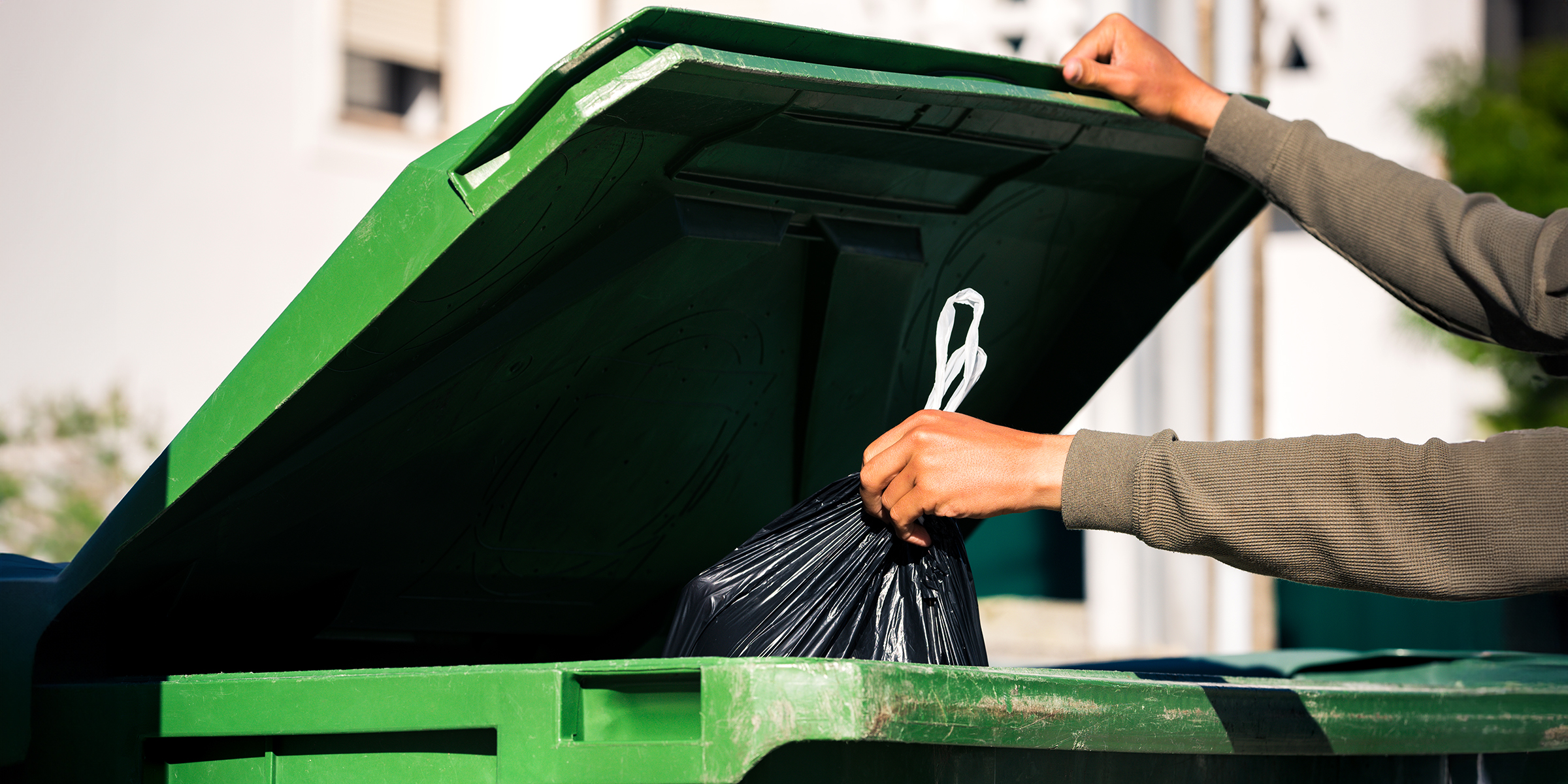 Une personne jetant des déchets dans une poubelle | Source : Shutterstock