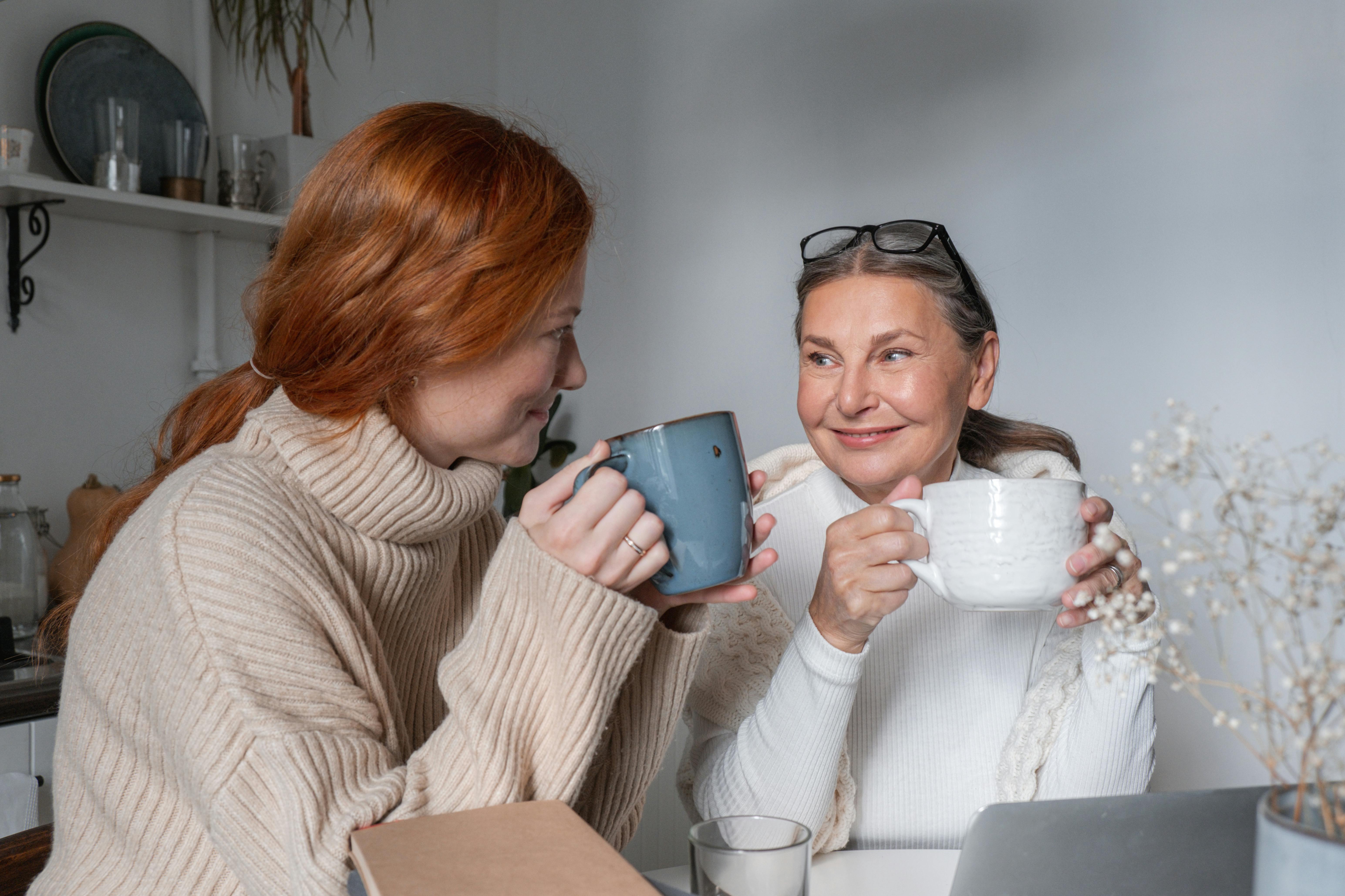 Une femme plus âgée et une plus jeune sourient en prenant une boisson ensemble | Source : Pexels