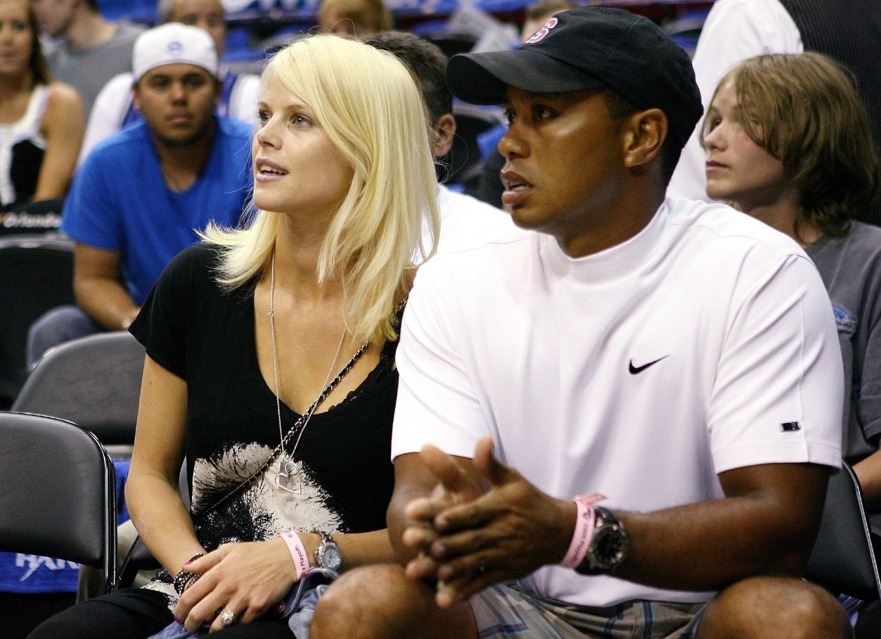 Tiger Woods est assis aux côtés de sa femme Elin pendant le quatrième match de la finale NBA 2009 entre les Lakers de Los Angeles et les Orlando Magic. | Photo : Getty Images