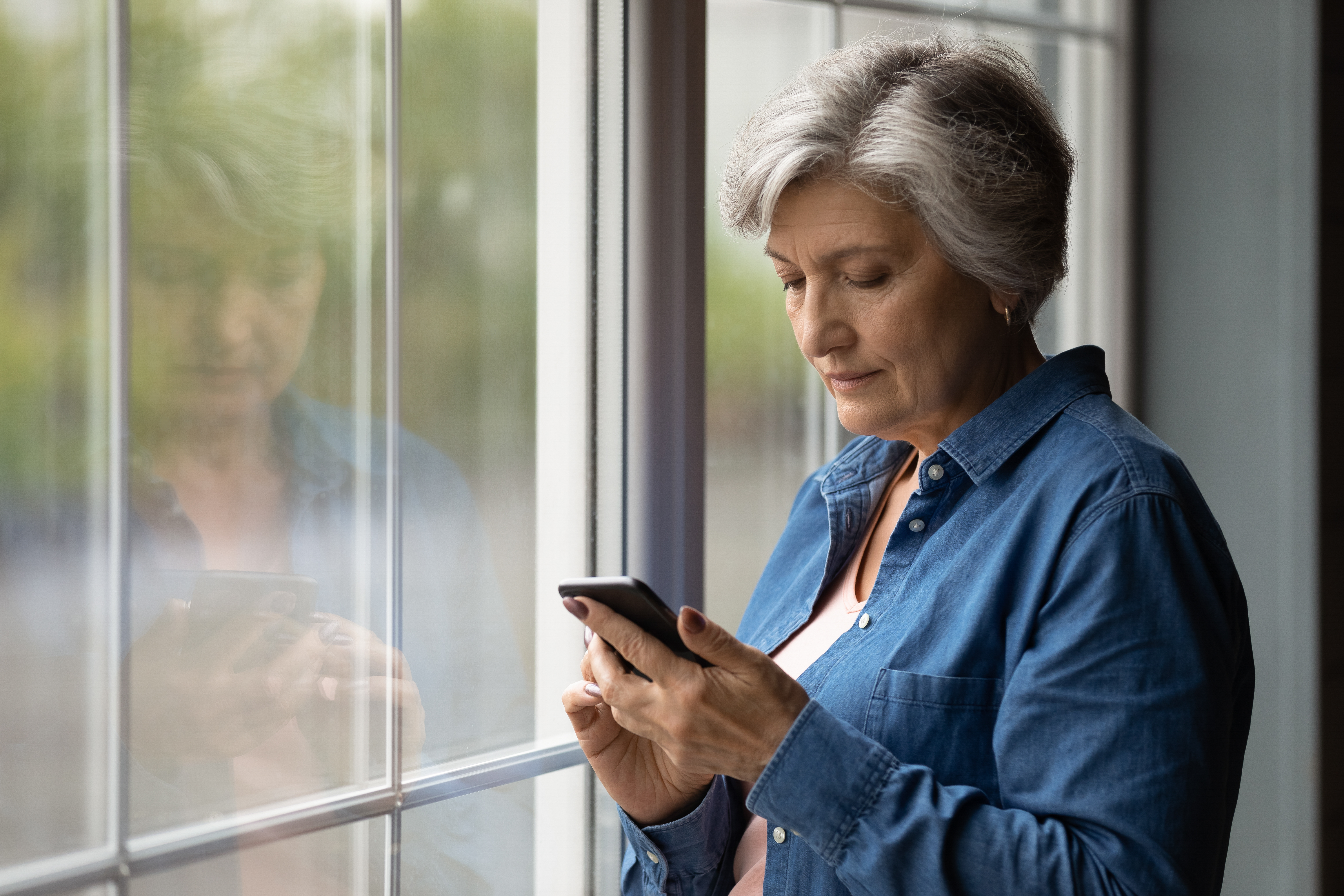 Femme âgée envoyant un texto et ayant l'air inquiet | Source : Shutterstock