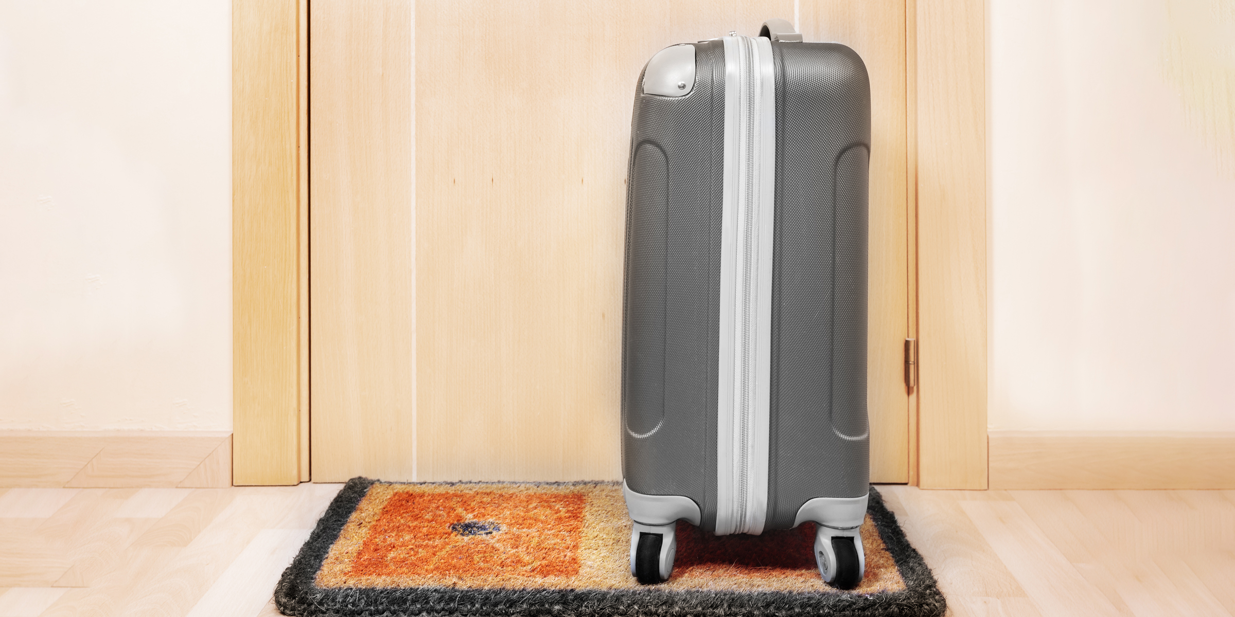 Une valise posée sur le pas de la porte | Source : Shutterstock