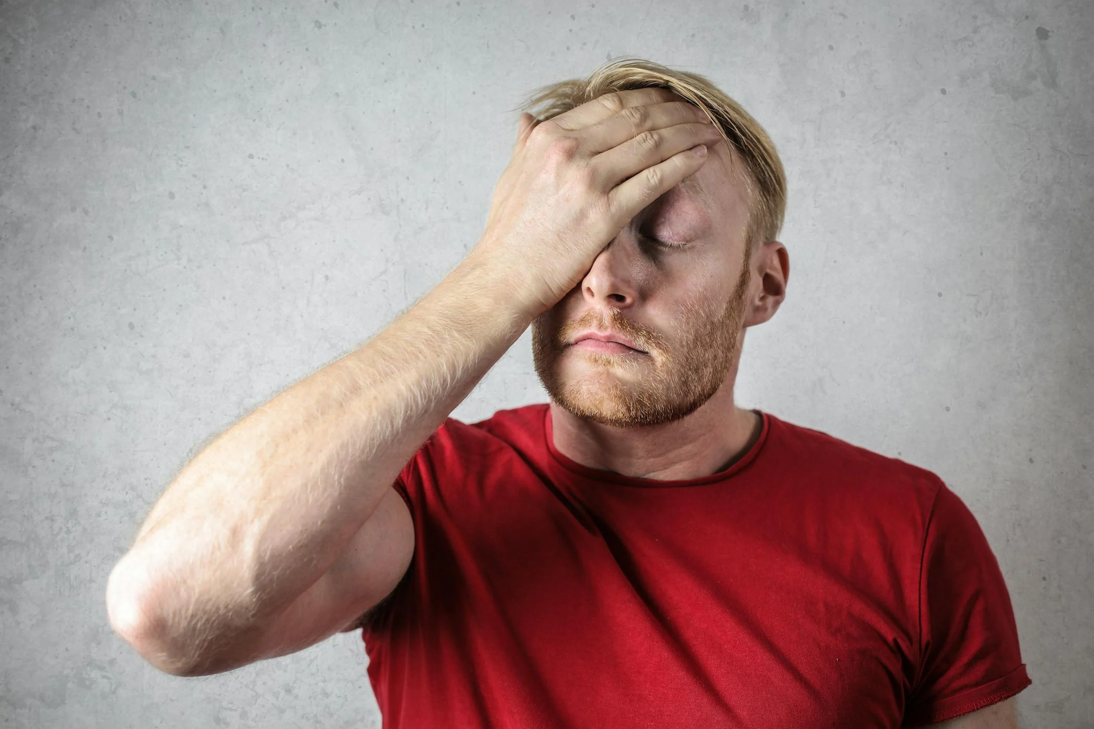 A tired man rubbing his face ⏐ Source: Pexels