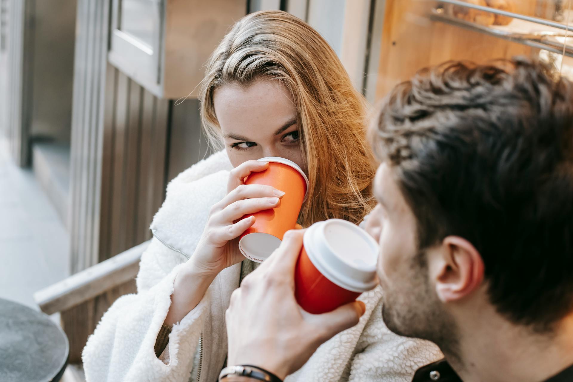 Un couple buvant des boissons chaudes et se regardant l'un l'autre dans un café | Source : Pexels