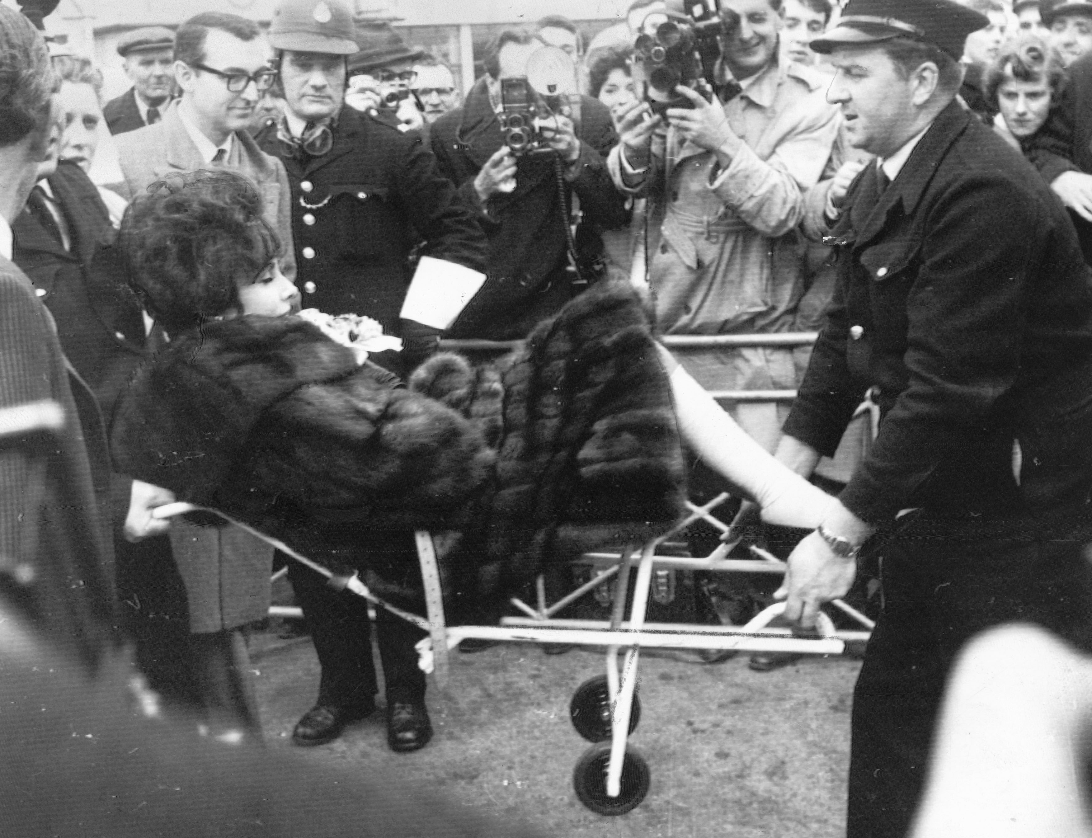 Elizabeth Taylor quittant une clinique londonienne sur un chariot le 26 mars 1961 | Source : Getty Images