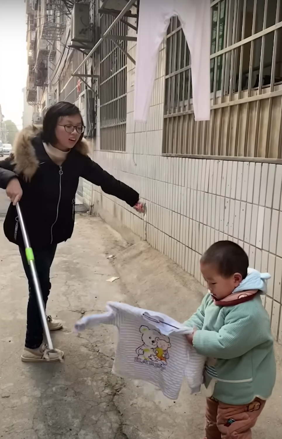 Pomelo aide sa mère à faire la lessive. | Source : Youtube.com/South China Morning Post