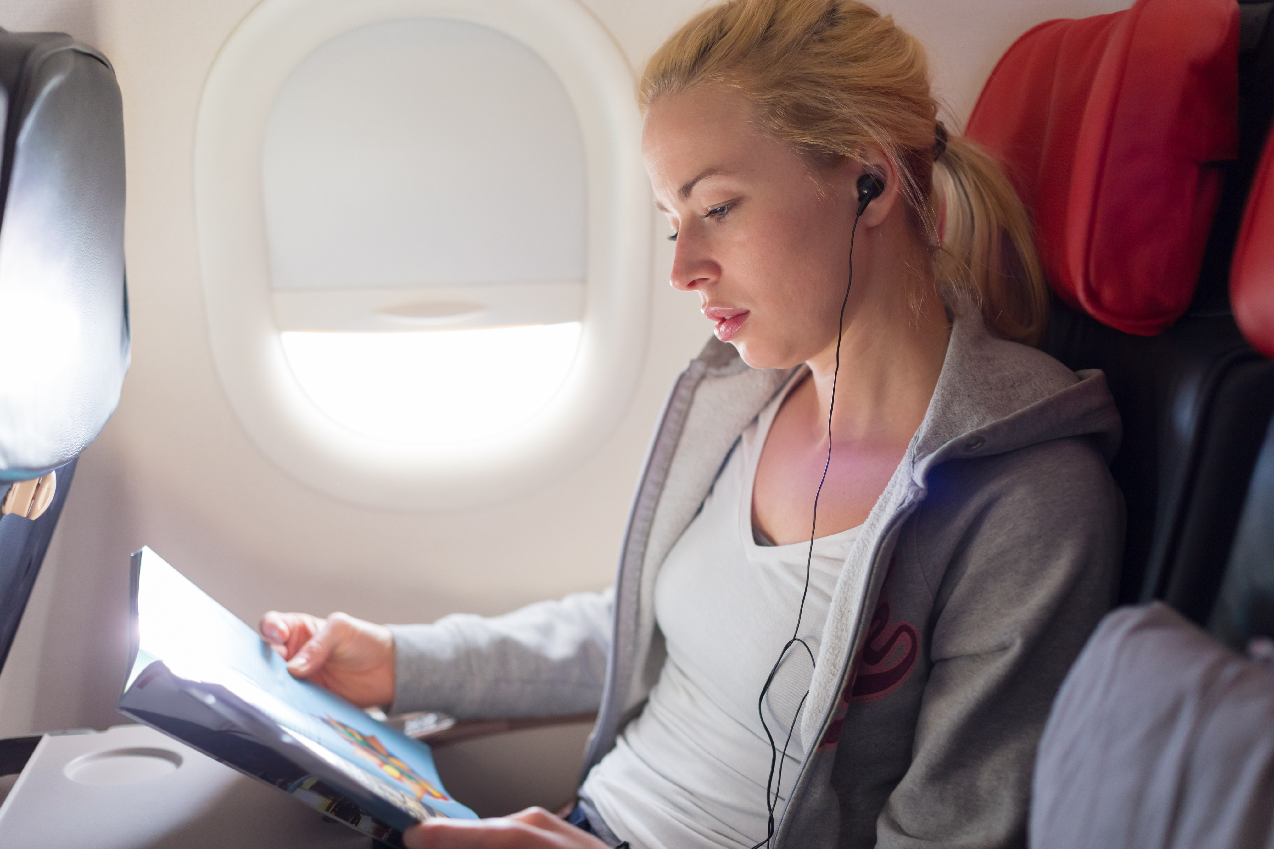 Une femme assise à la fenêtre d'un avion | Source : Shutterstock