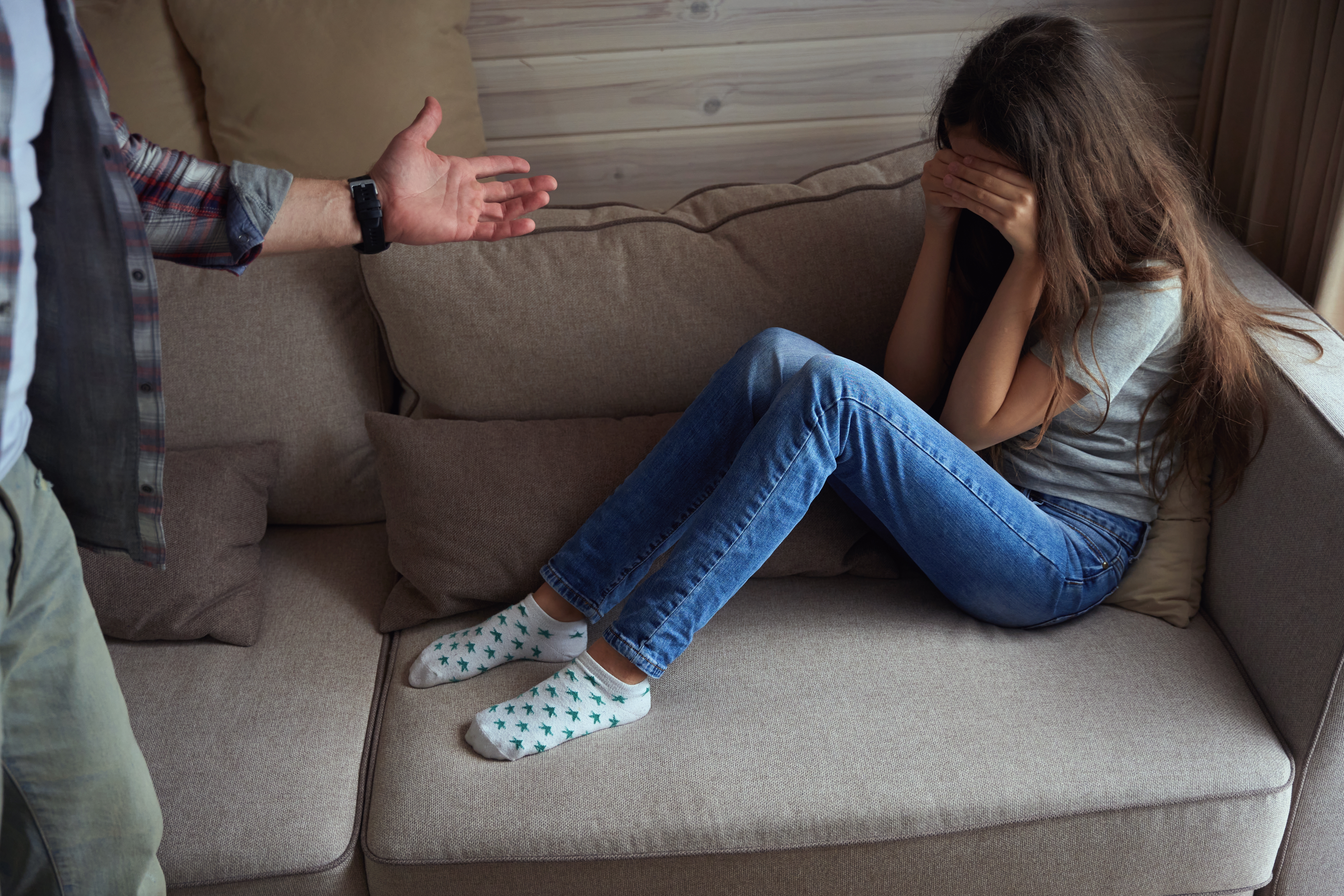 Une adolescente qui pleure pendant que son père la gronde | Source : Shutterstock
