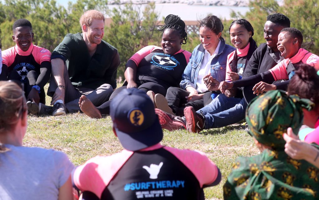 Prince Harry et Meghan se joignent aux mentors de surf et participent à une activité de groupe lors de leur visite à Waves for Change, une ONG, à Monwabisi Beach. | Source: Getty Images