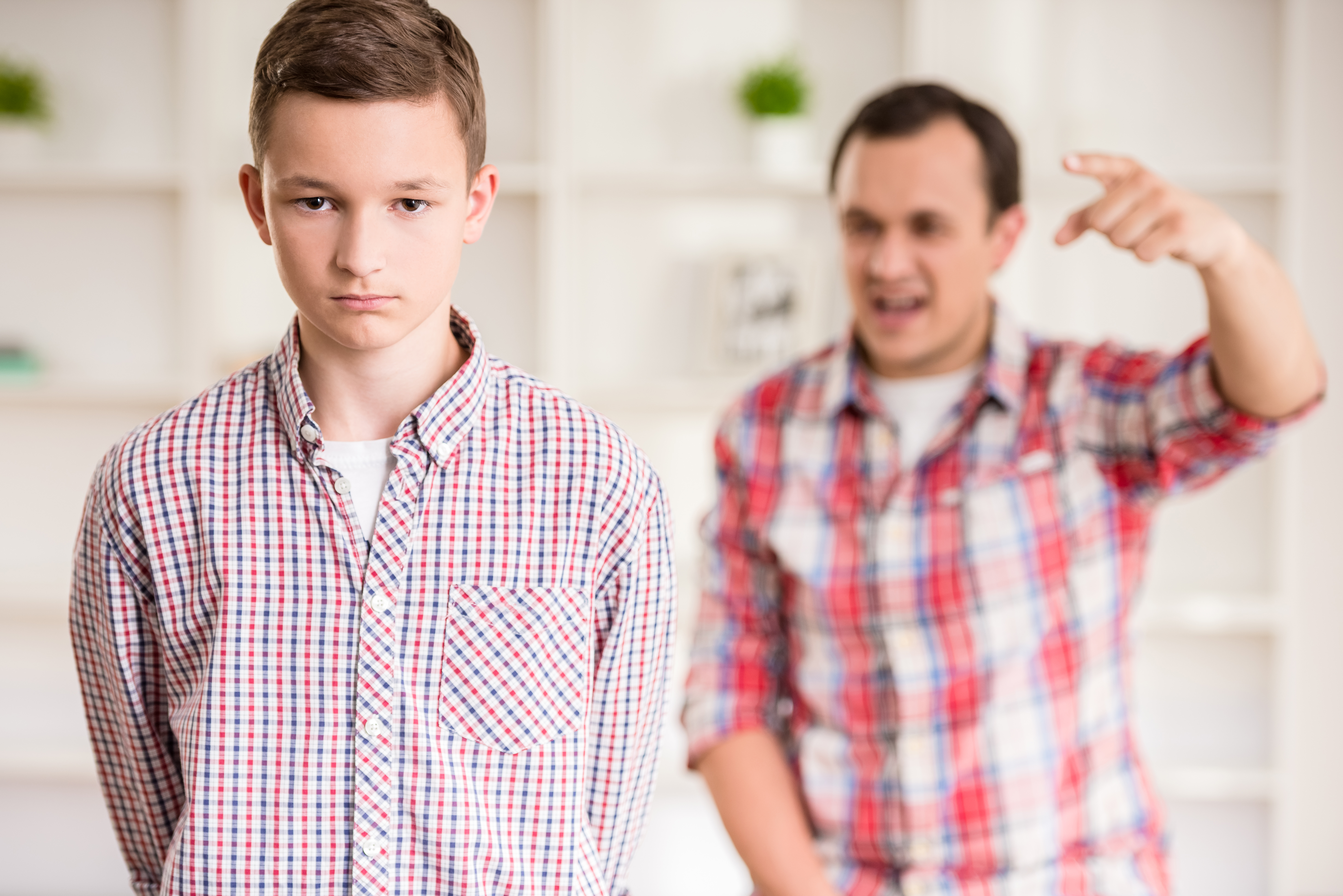 Un jeune garçon se faisant gronder par son père | Source : Shutterstock