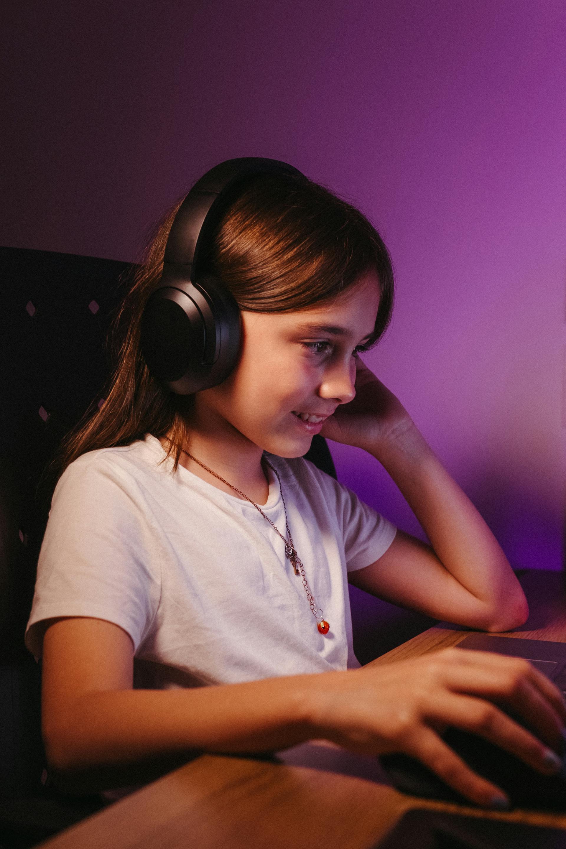 Une adolescente utilisant un casque et un ordinateur | Source : Pexels