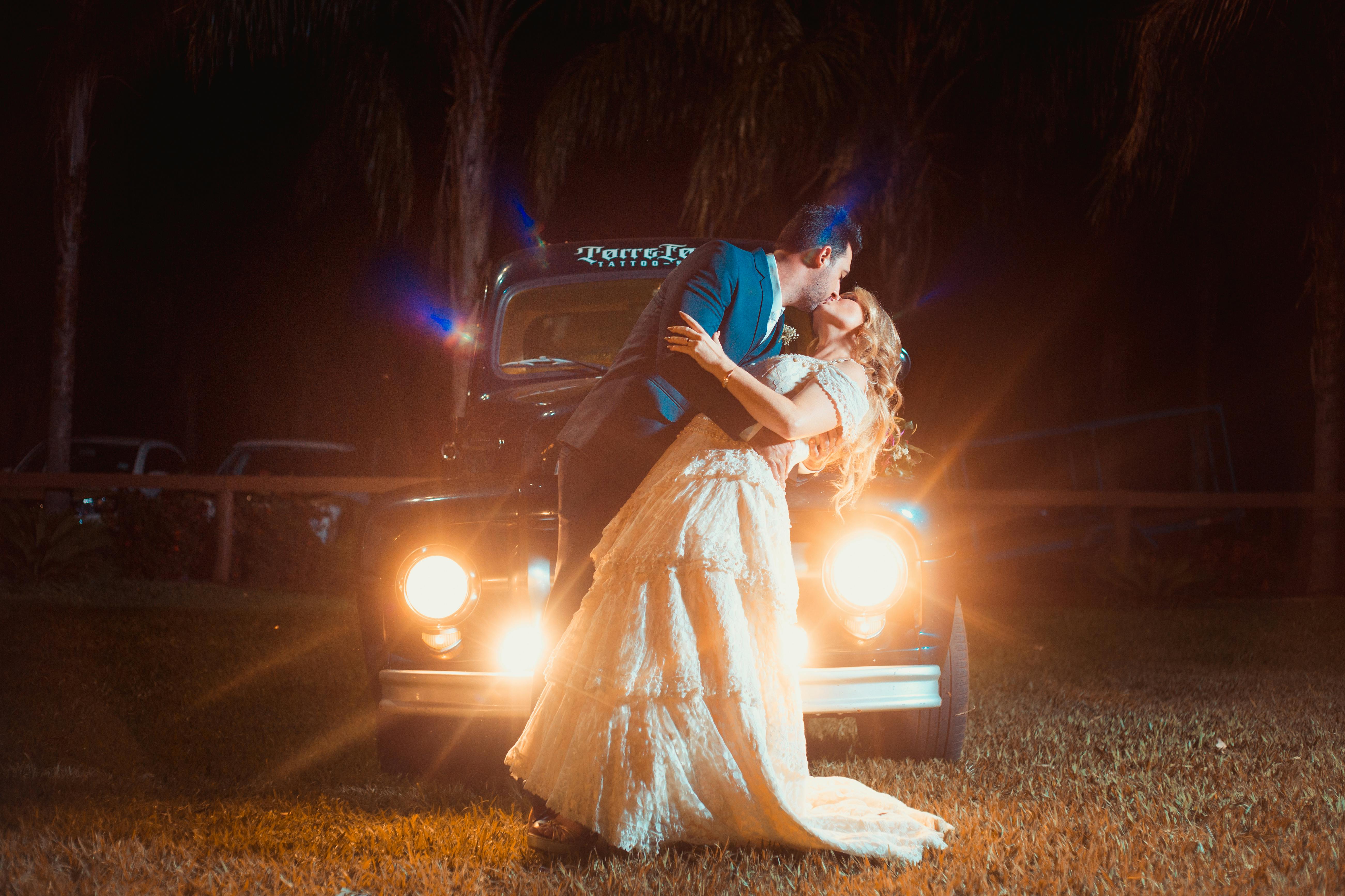 Un homme et une femme s'embrassent passionnément devant une voiture | Source : Pexels