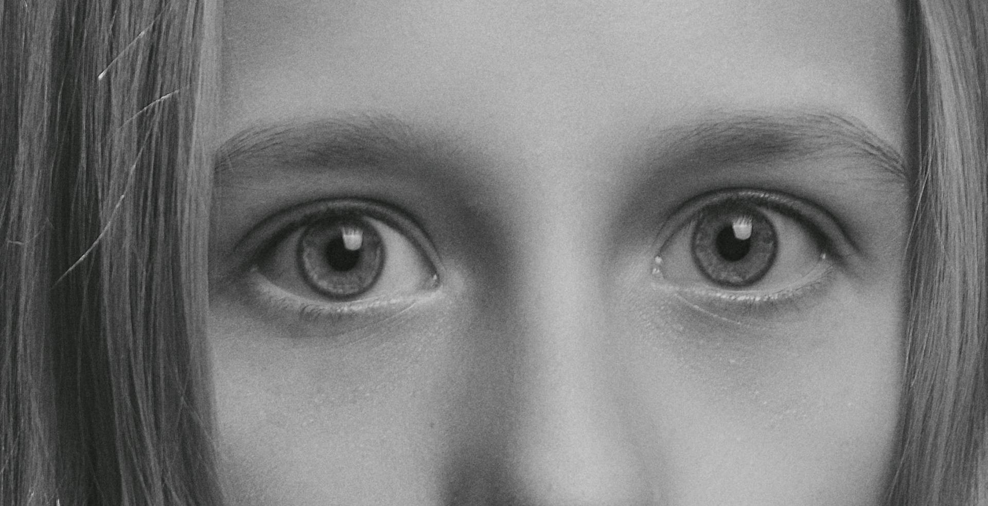 Photo en niveaux de gris des yeux d'une fille effrayée | Source : Pexels