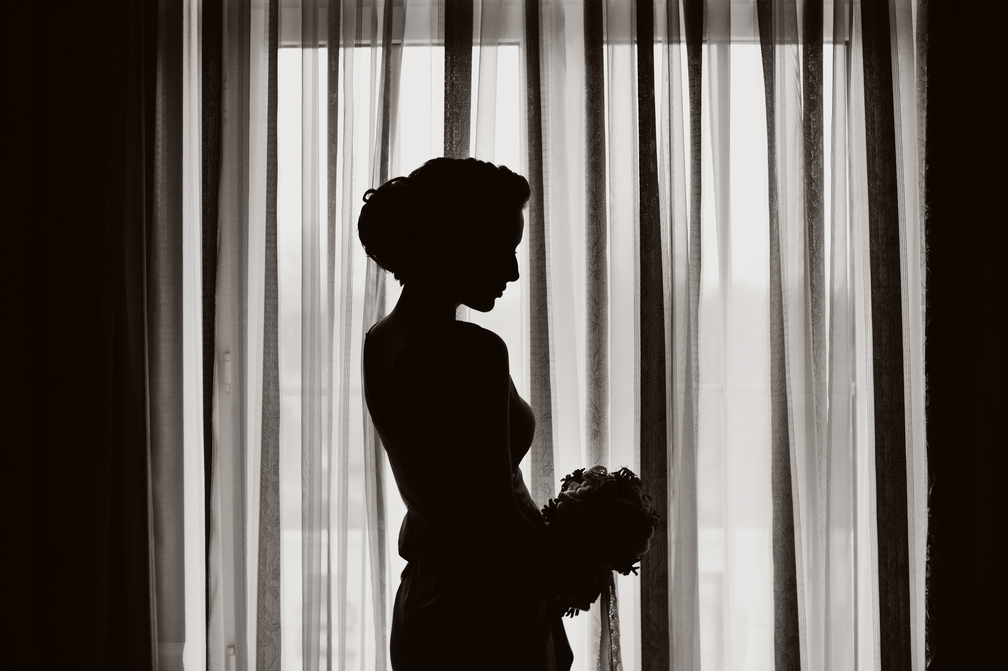 Silhueta de uma mulher em pé perto de uma janela |  Fonte: Shutterstock