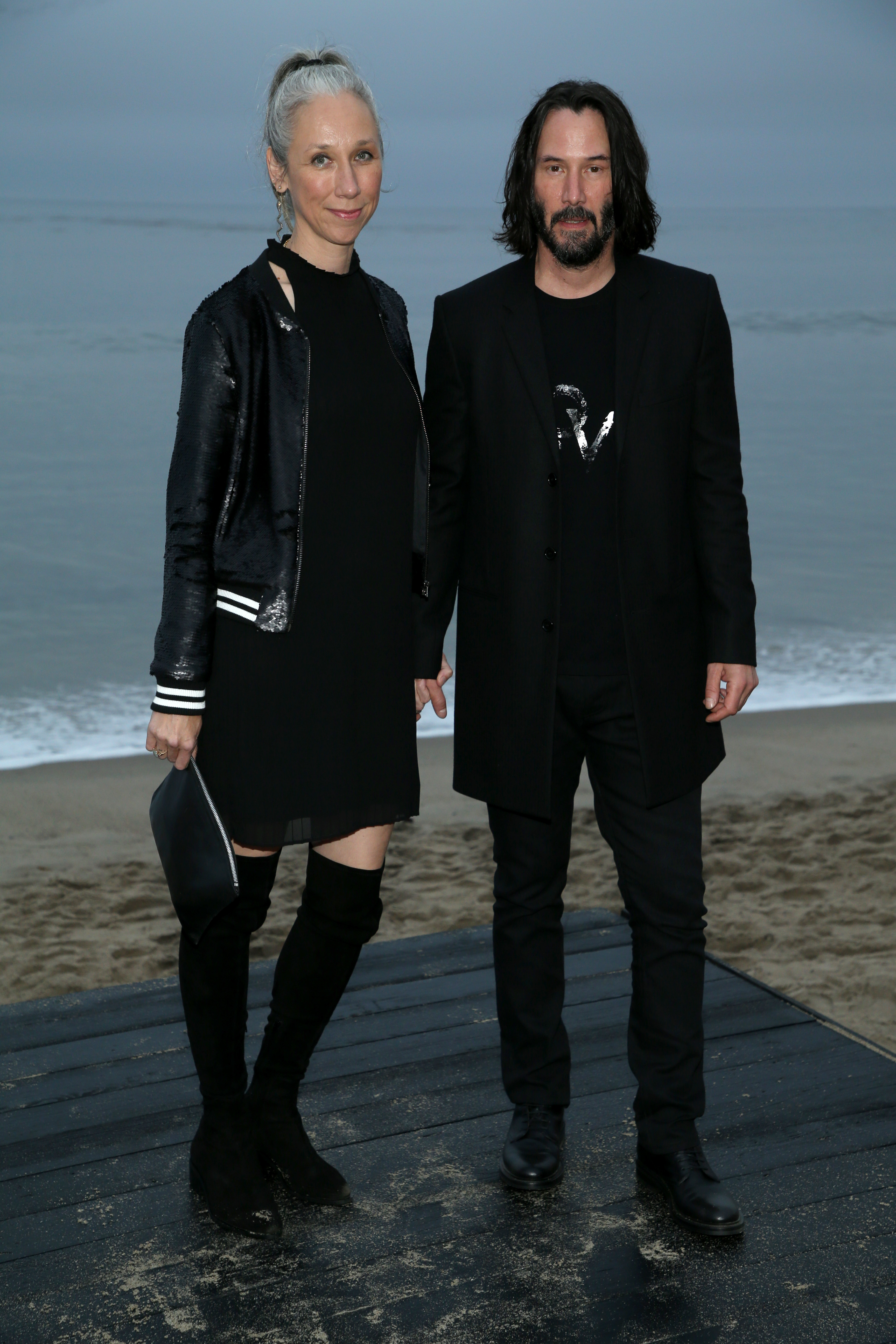 Alexandra Grant et Keanu Reeves assistent au défilé printemps/été 2020 de Saint Laurent Men à Malibu, en Californie, le 6 juin 2019 | Source : Getty Images