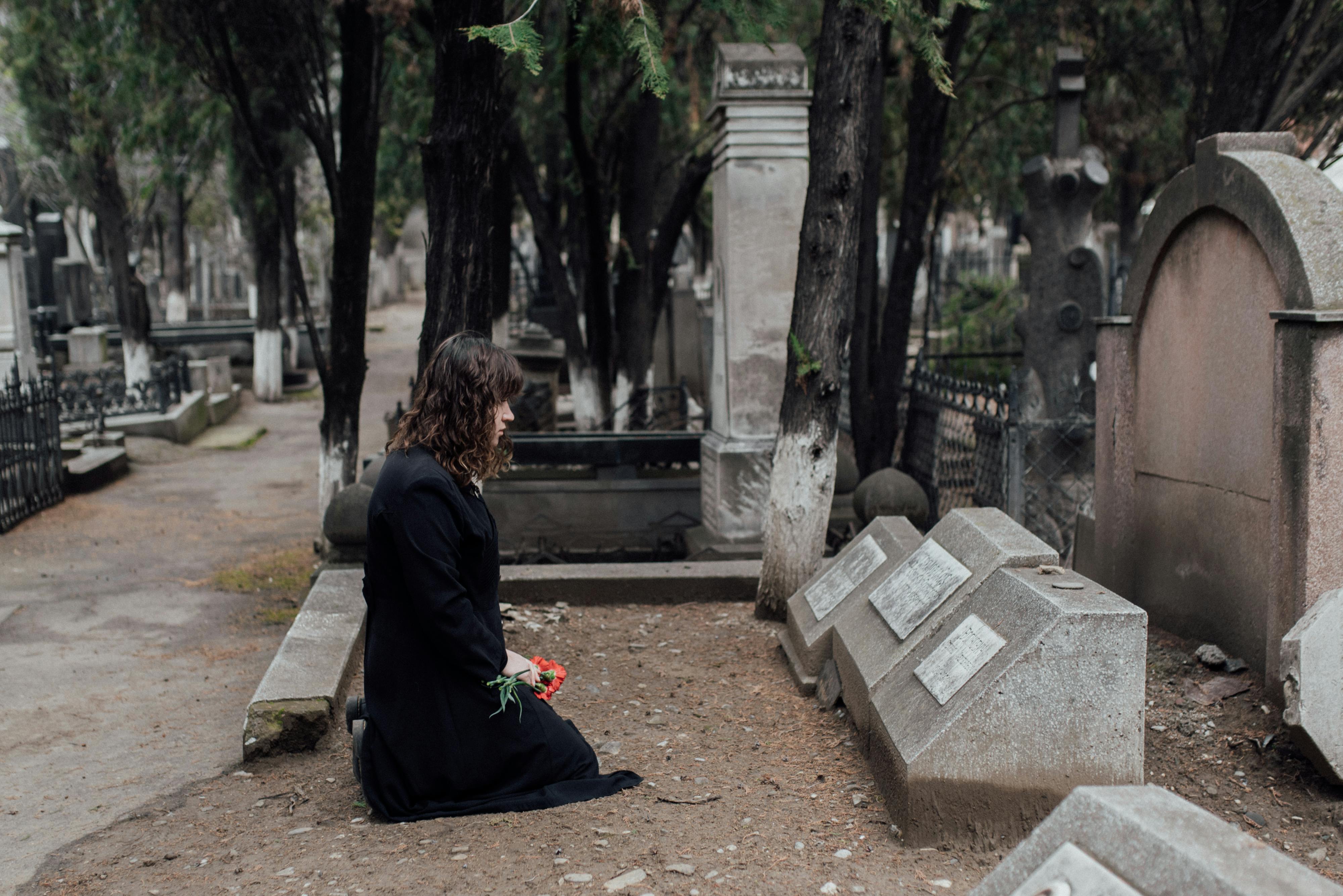 Femme portant une robe noire sur une tombe | Source : Pexels