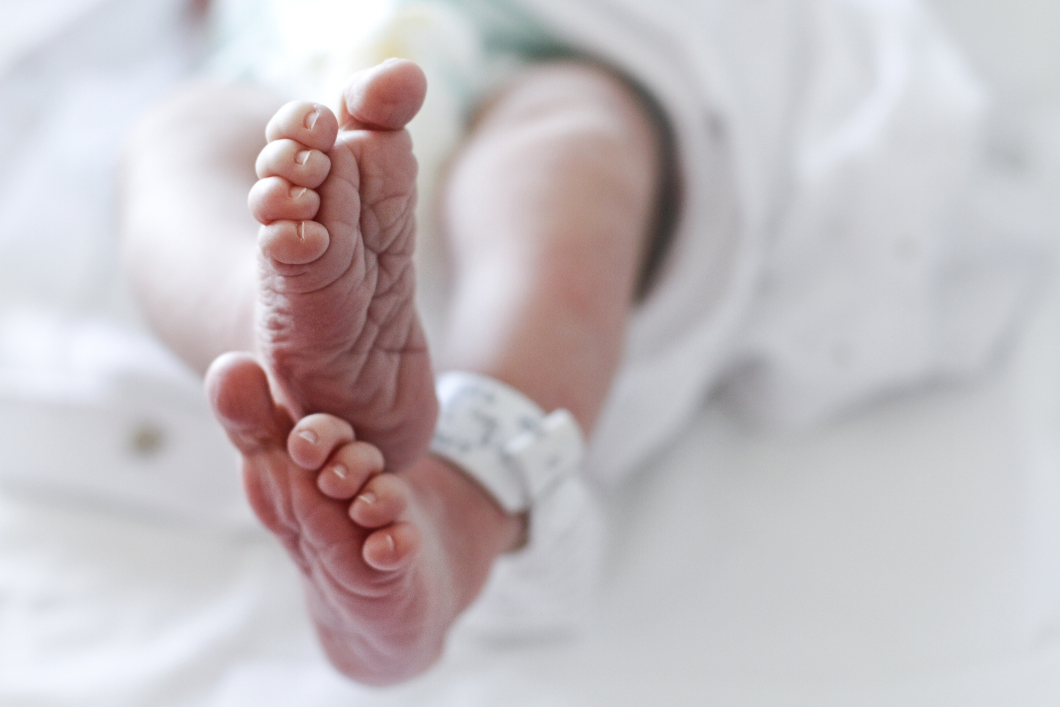 Gros plan sur un nouveau-né de sexe masculin à l'hôpital, avec une étiquette d'identification aux pieds I Photo d'illustration I Source : Getty Images