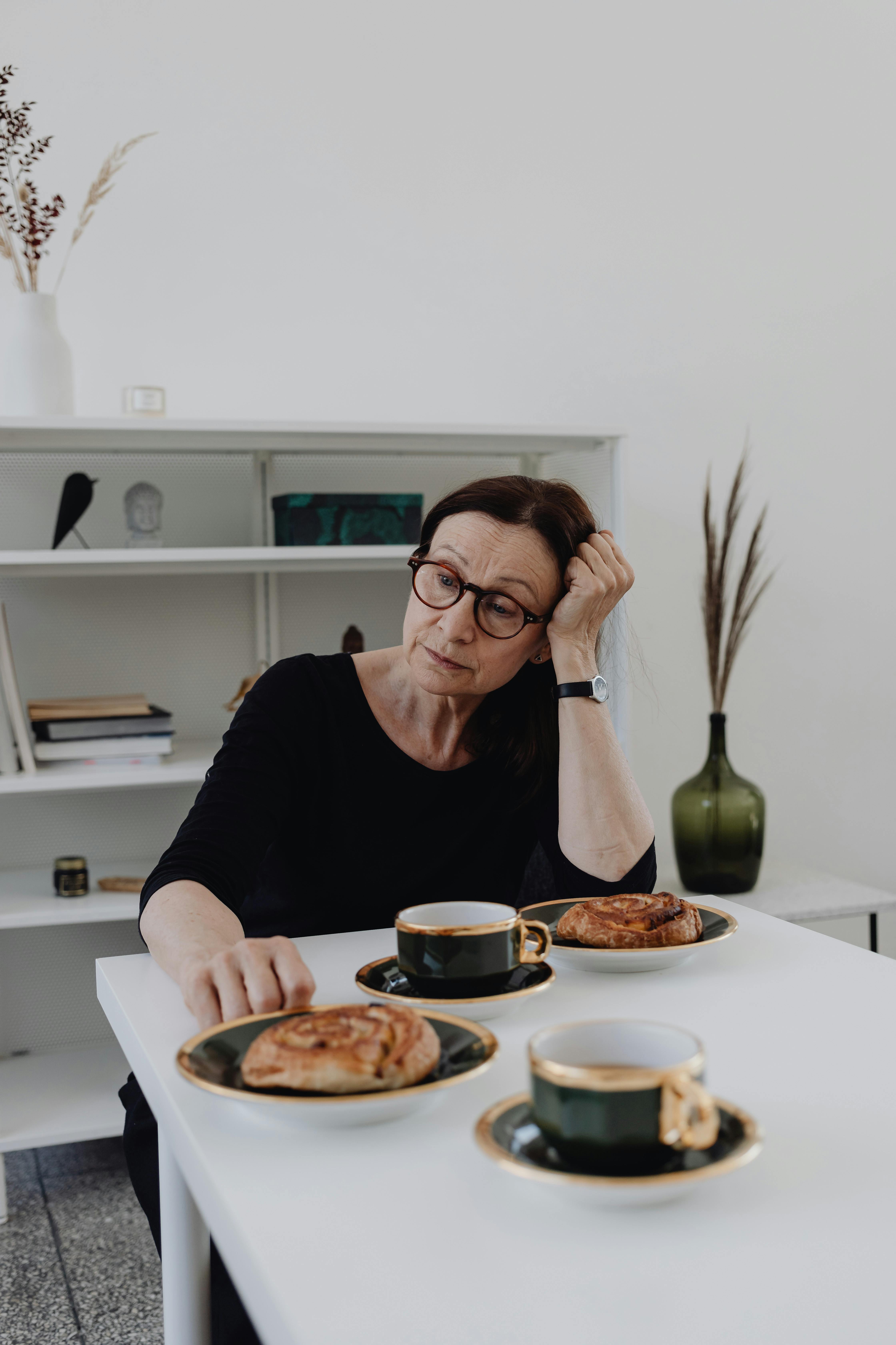 Une femme triste assise à une table | Source : Pexels