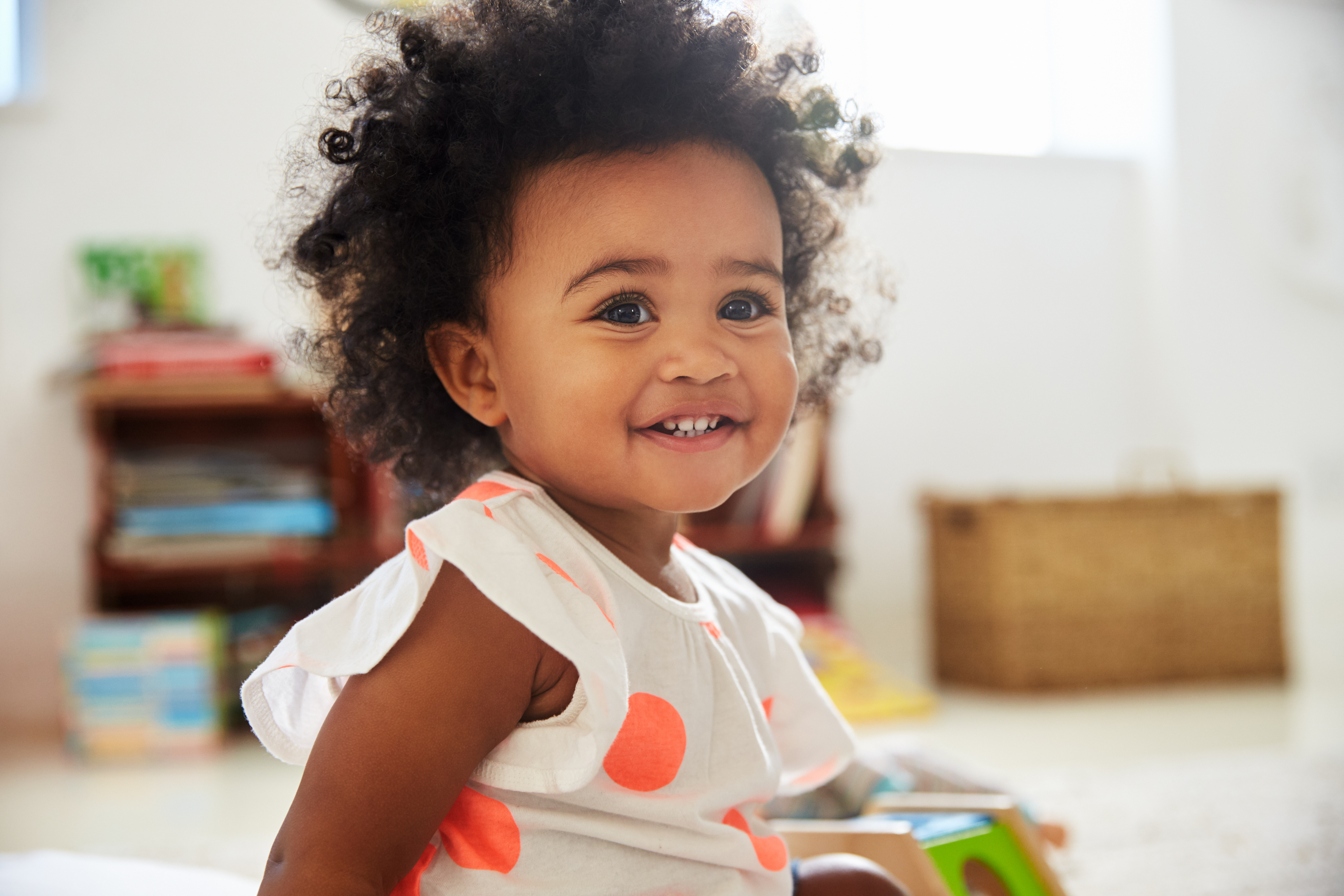 Une petite fille qui sourit dans une salle de jeux | Source : Shutterstock