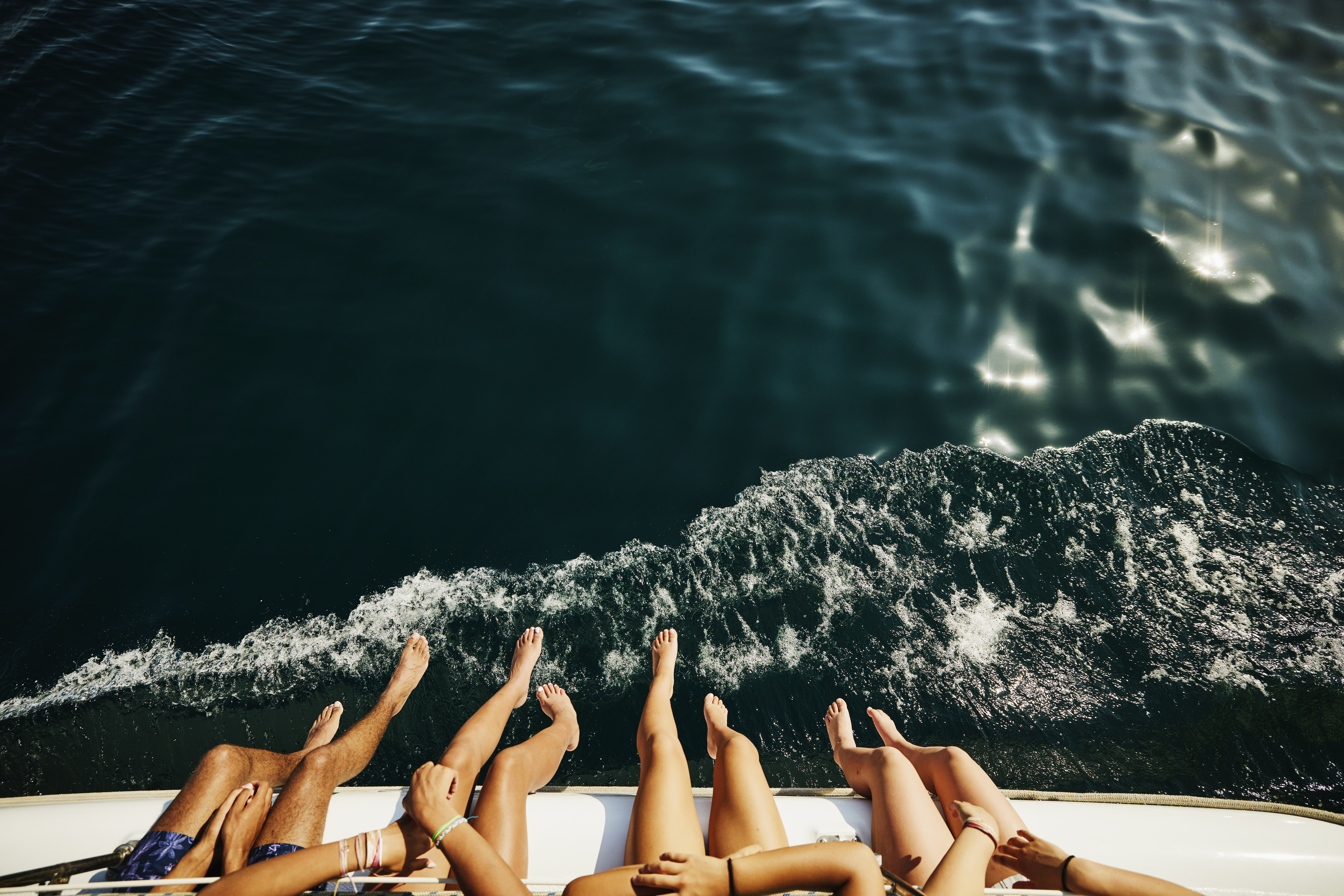Une photo de personnes se balançant les jambes par-dessus le bord d'un bateau | Source : Getty Images