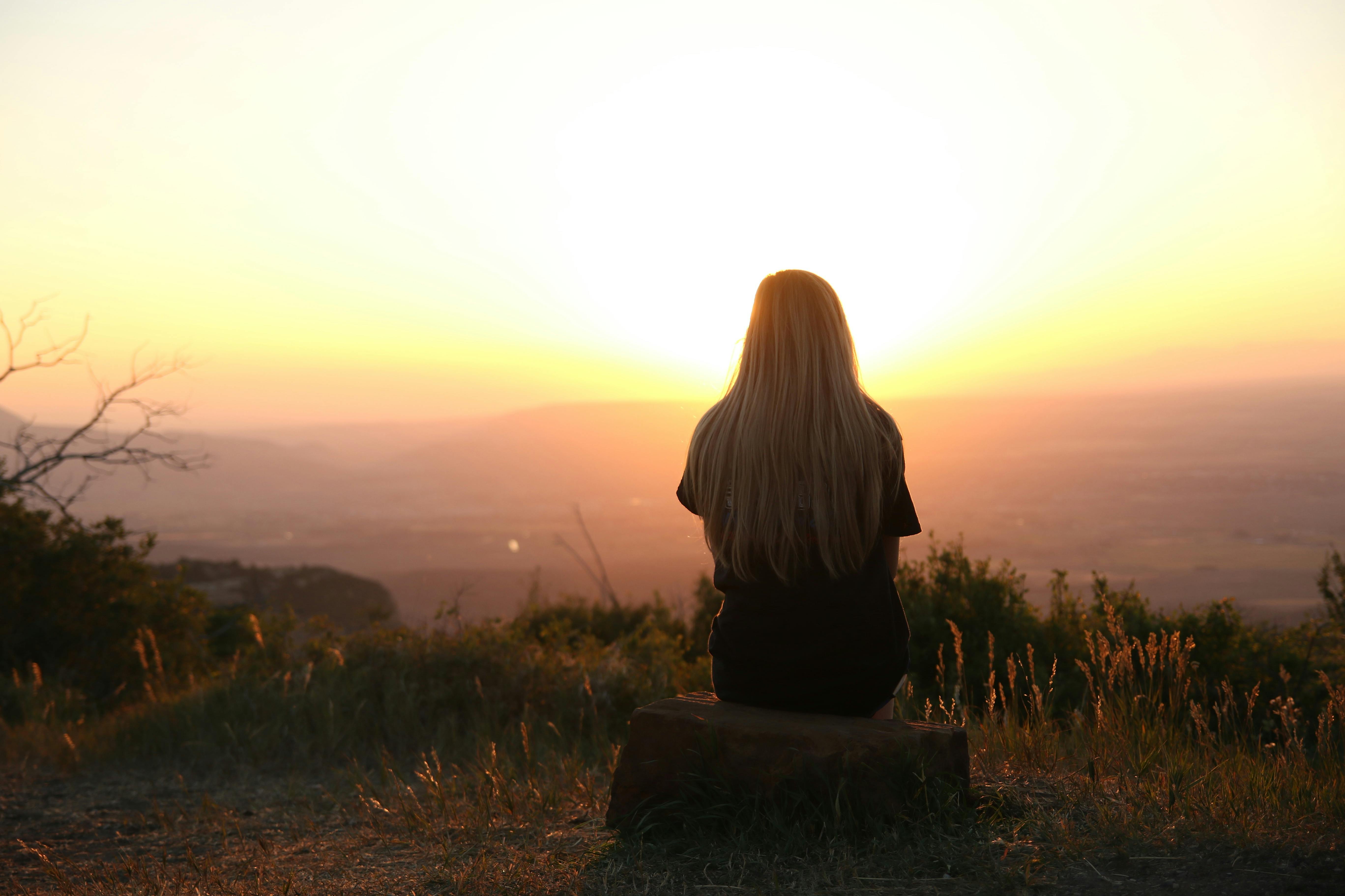 Une femme regardant le coucher de soleil | Source : Pexels