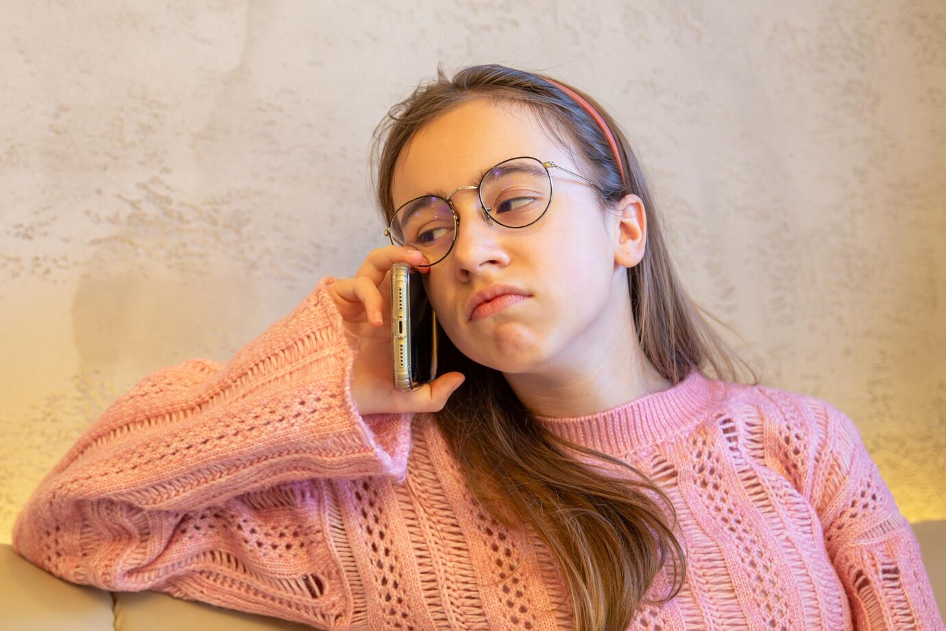 Une jeune femme triste qui parle au téléphone | Source : Freepik