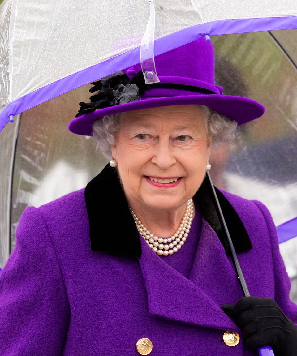 La Reine Elizabeth II s'abrite sous un parapluie lors de l'ouverture des nouveaux Jubilee Gardens le 25 octobre 2012 à Londres, en Angleterre. | Photo : Getty Images
