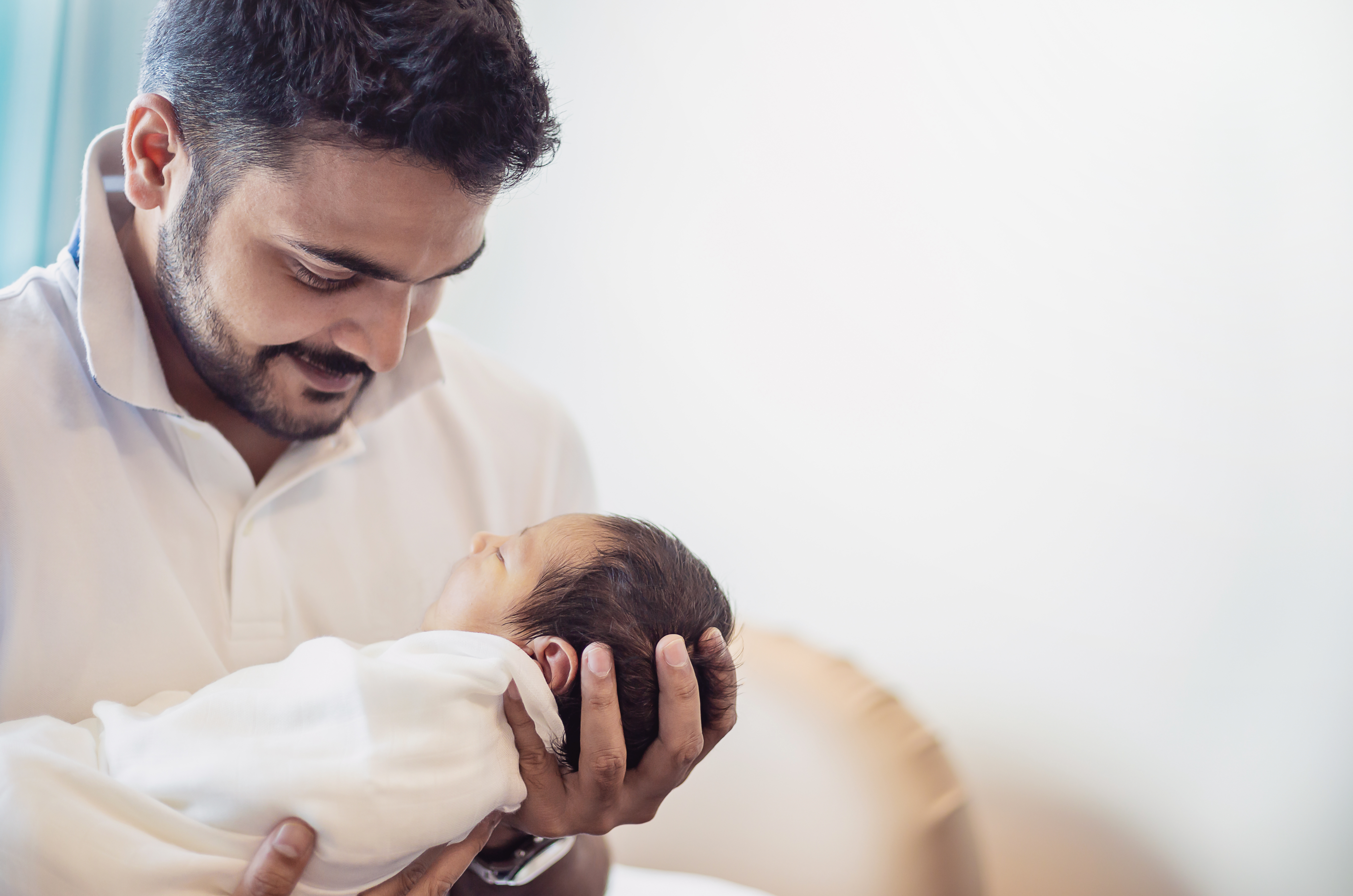 Un homme tenant un nouveau-né | Source : Shutterstock