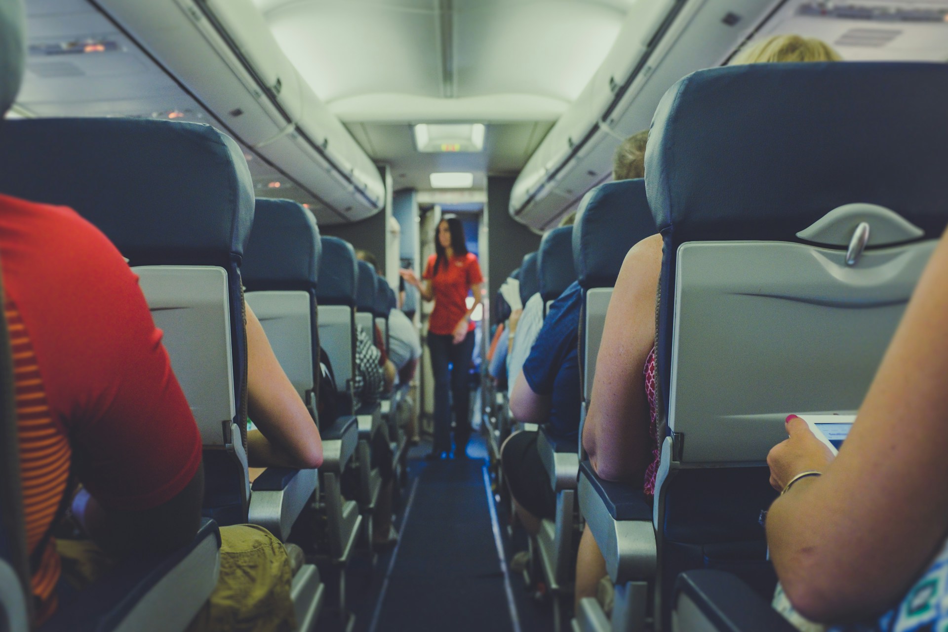 Une hôtesse de l'air examine les problèmes des passagers dans le couloir économique | Source : Unsplash