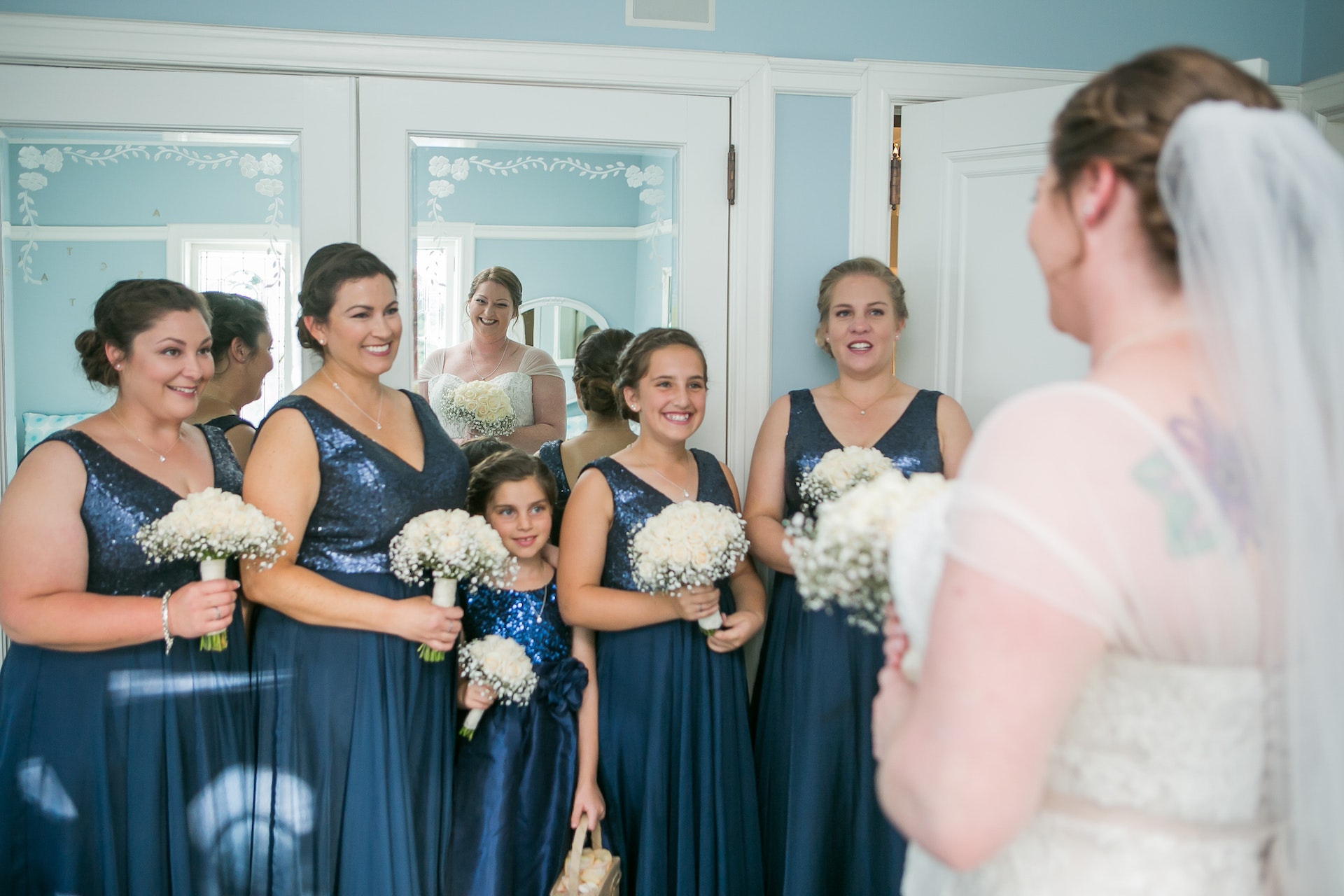 Une jeune demoiselle d'honneur debout avec d'autres demoiselles d'honneur devant la mariée | Source : Pexels