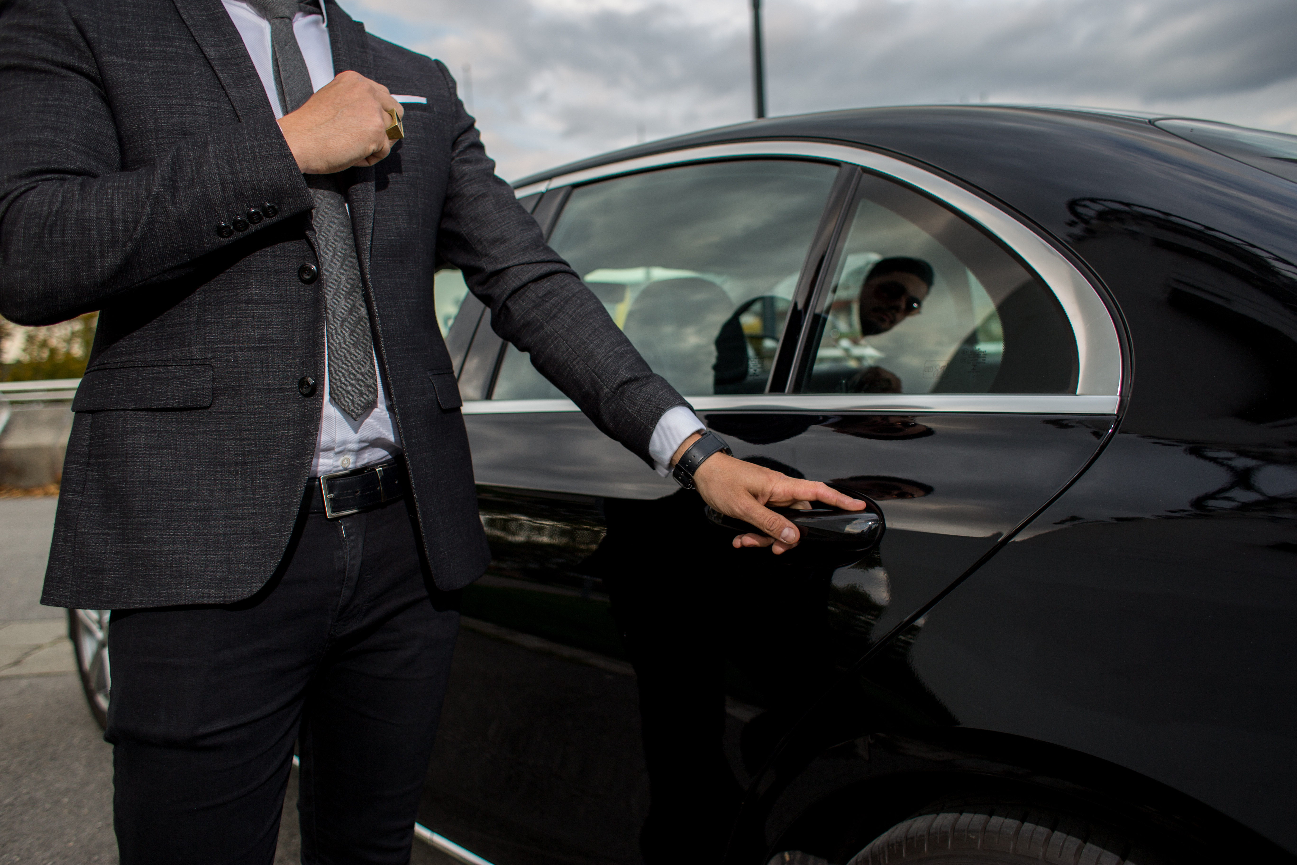 Voiture noire avec le conducteur qui tient la portière | Shutterstock