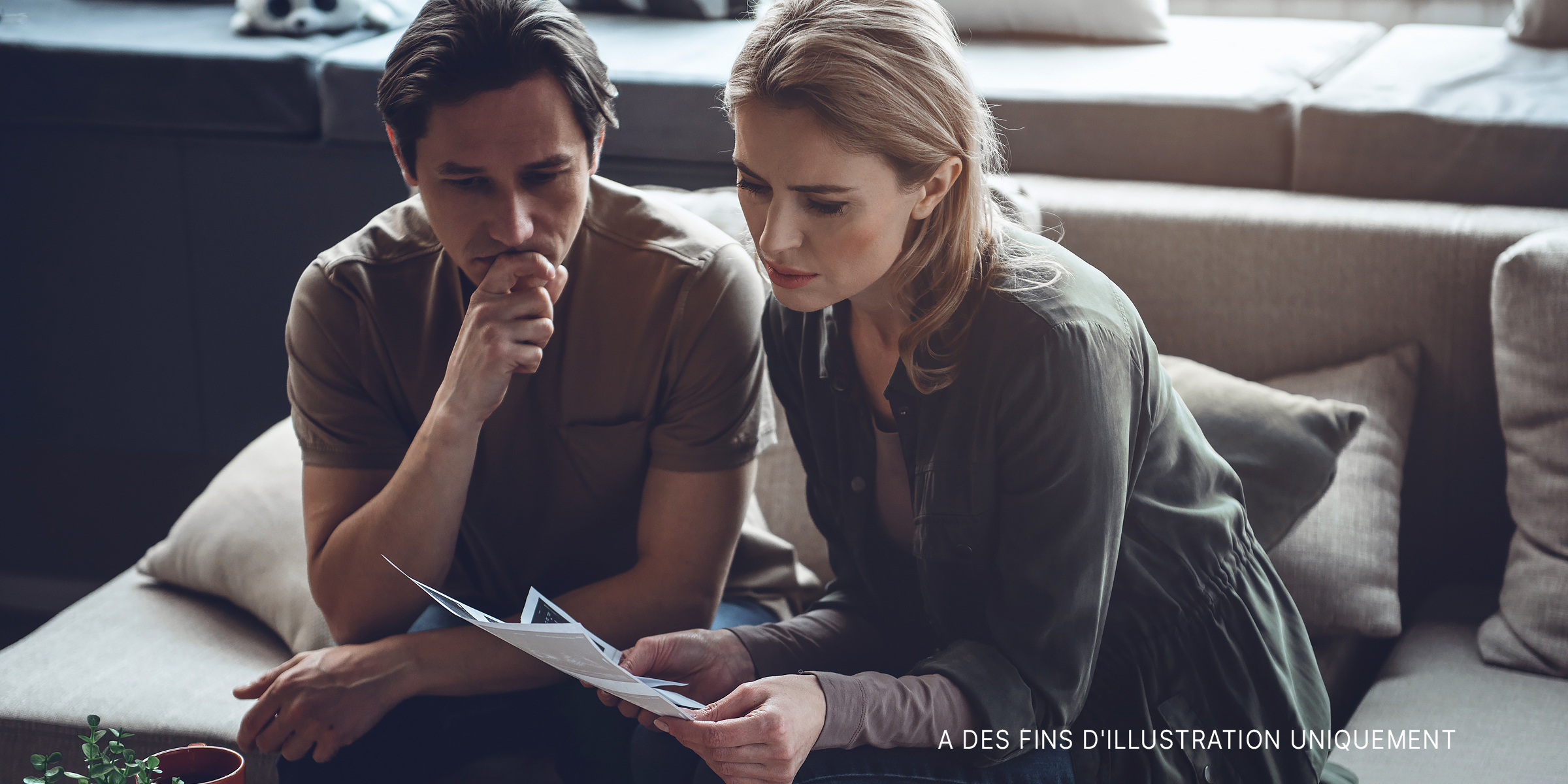 Couple déprimé regardant un document | Source : Shutterstock