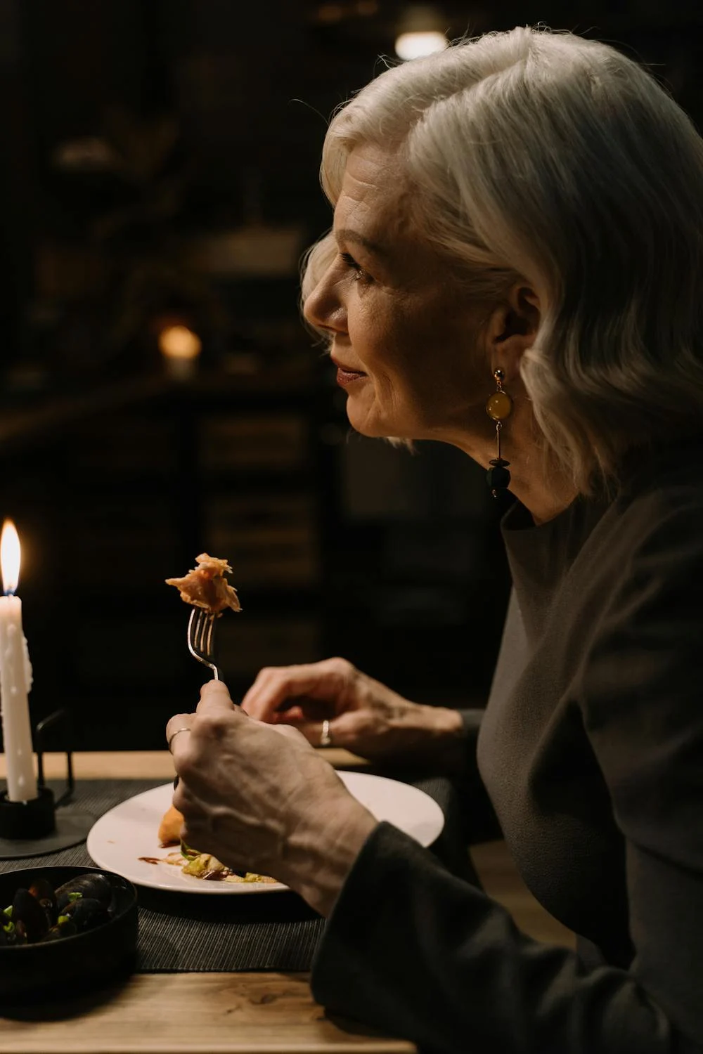 Une femme âgée souriante dans un restaurant | Source : Pexels