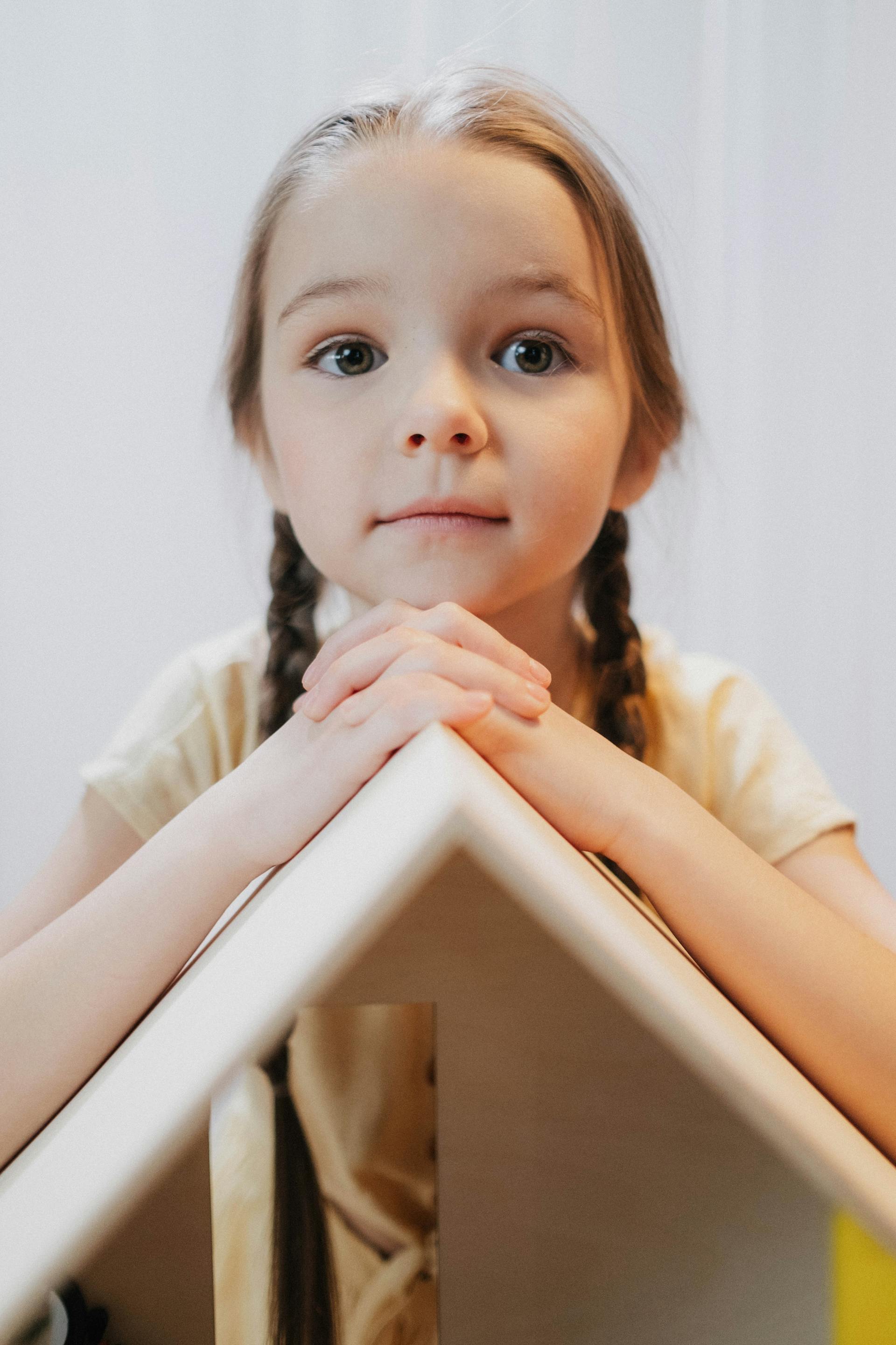 Une petite fille qui joue avec sa maison de poupée | Source : Pexels