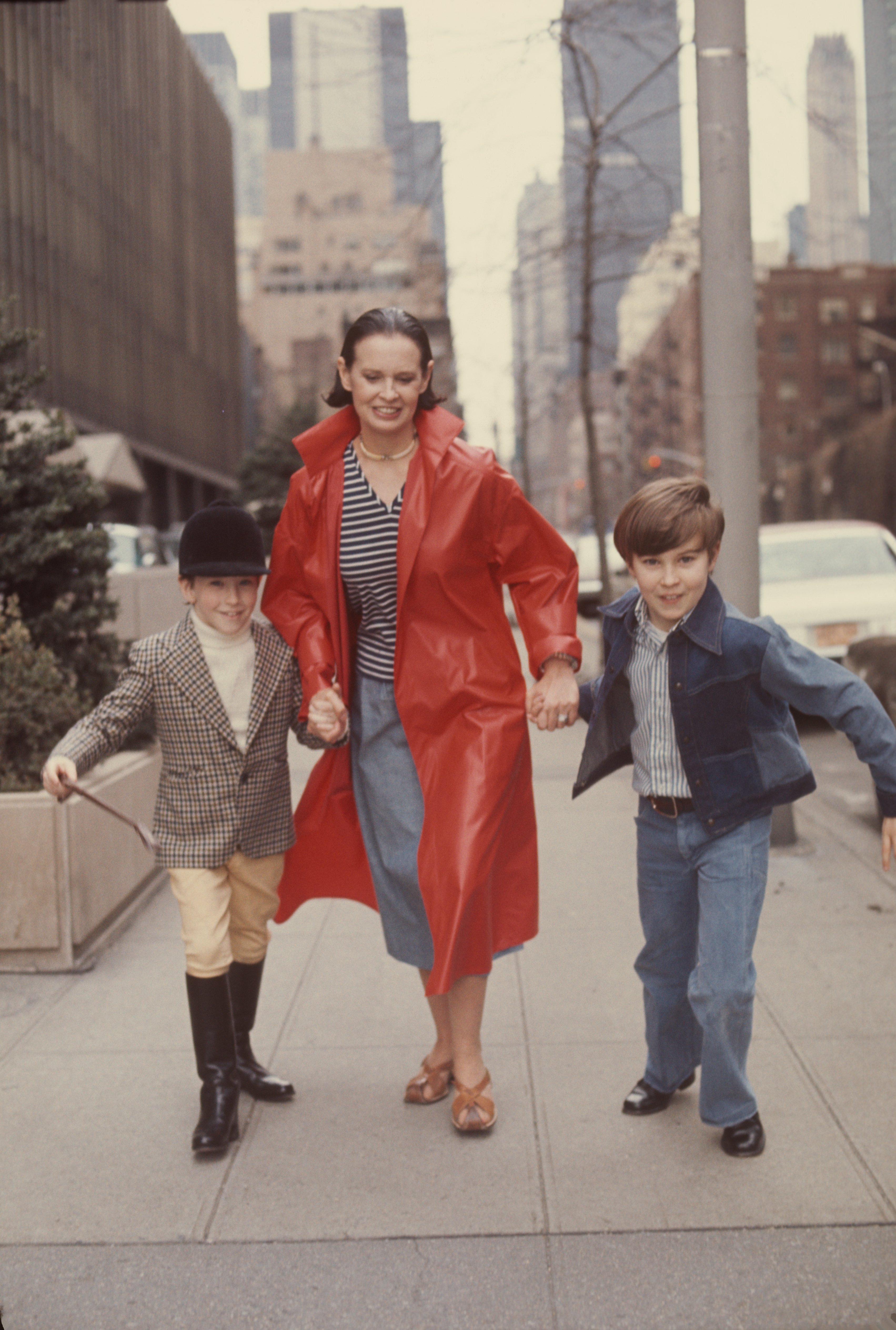 La mondaine d'origine suisse Gloria Vanderbilt court dans une rue avec ses deux fils Anderson Cooper et Carter Vanderbilt Cooper (1965 - 1988), New York, New York, mars 1976 | Source : Getty Images