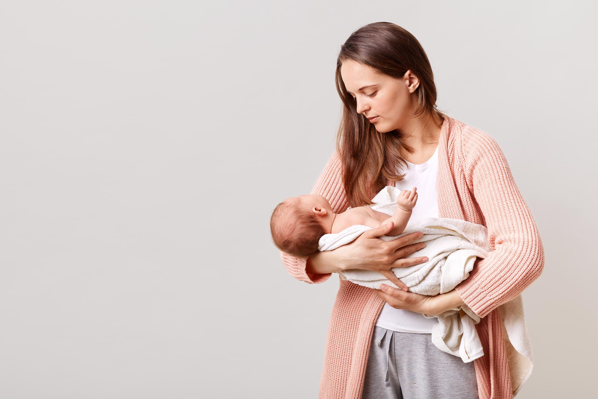 Une femme tenant un bébé | Source : Freepik