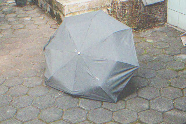 Vieux petit parapluie noir cassé | Source : Shutterstock