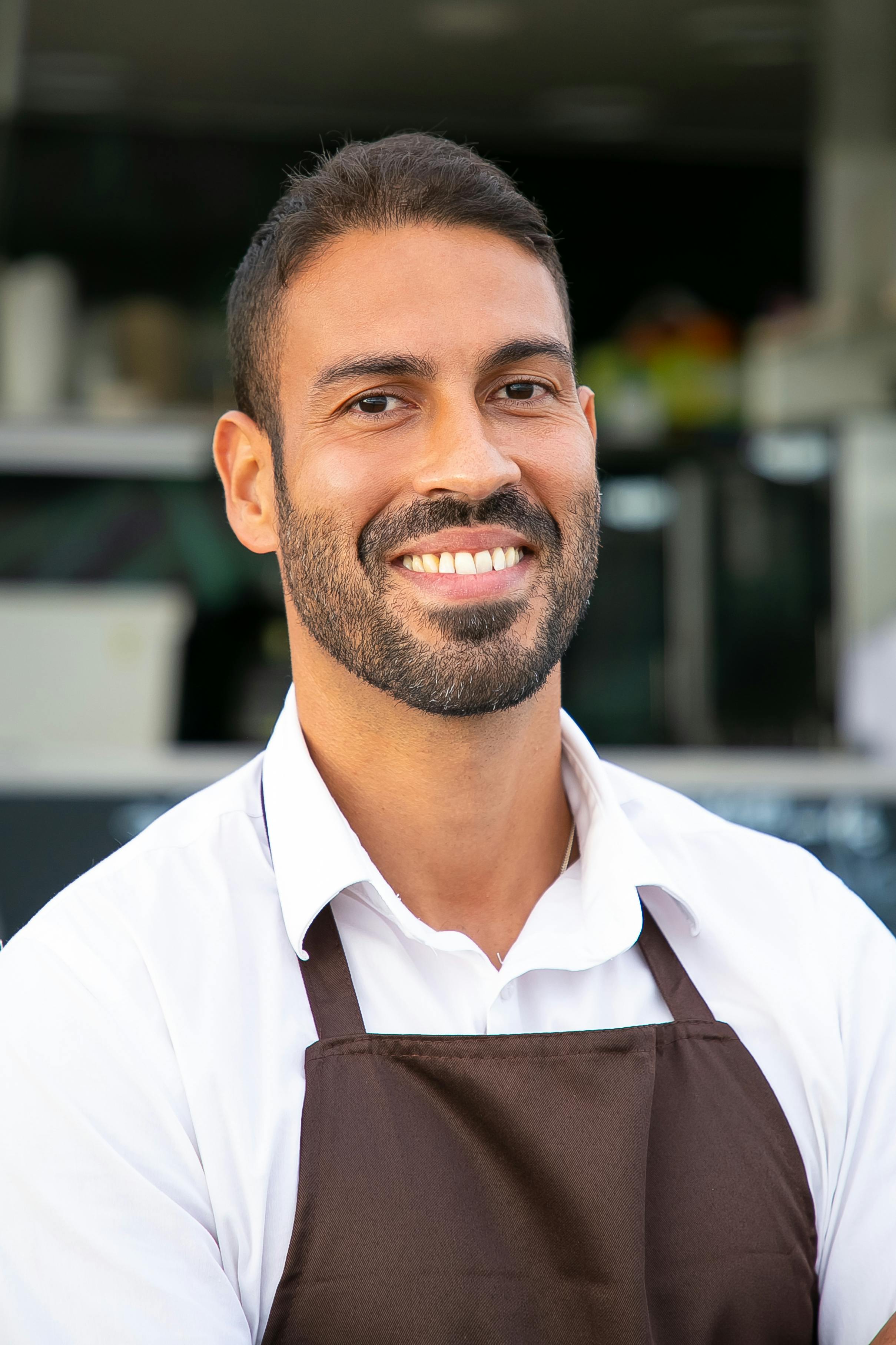 Un homme heureux et souriant vêtu d'un tablier | Source : Pexels