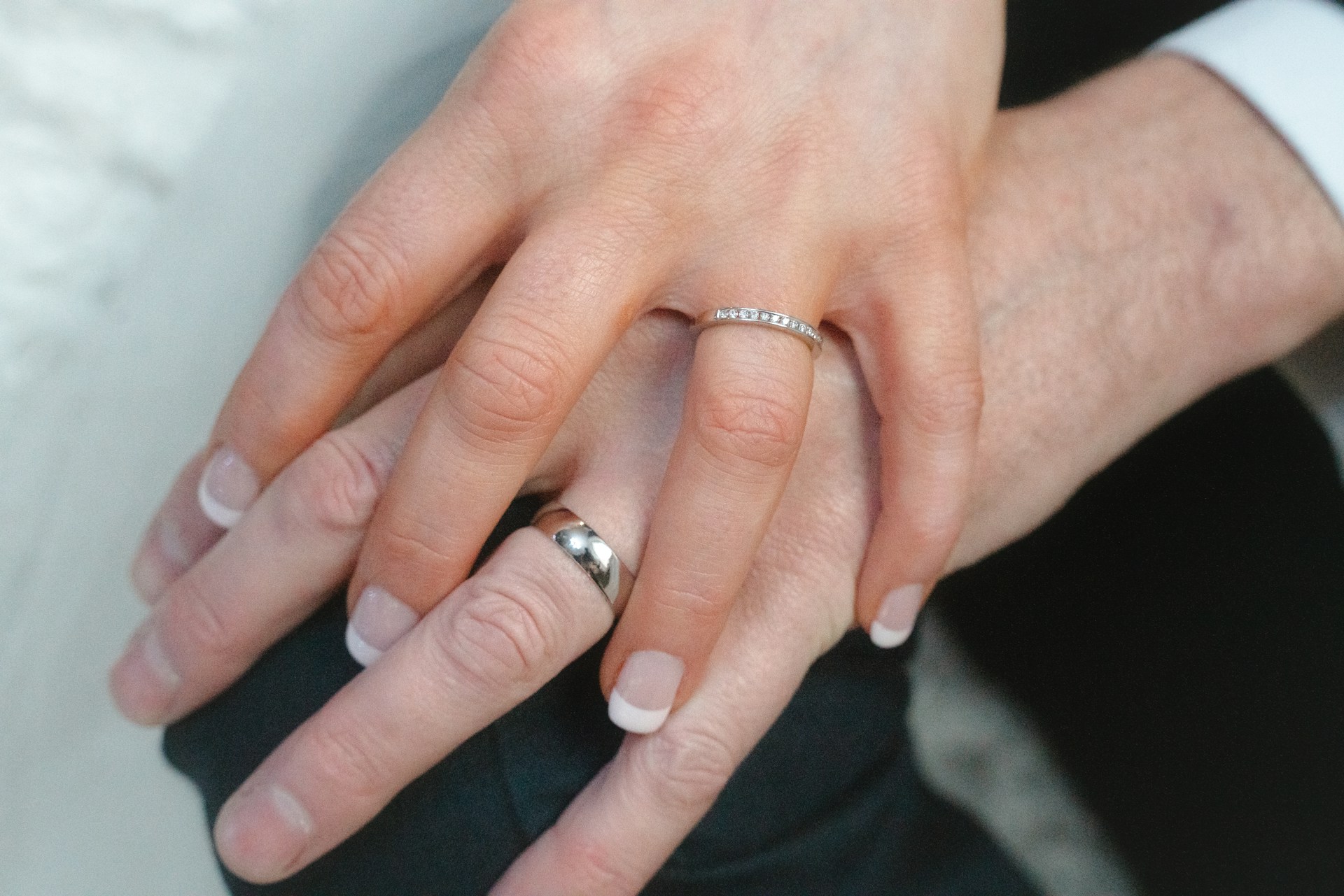 Un couple se tenant par la main, exhibant leurs alliances | Source : Unsplash
