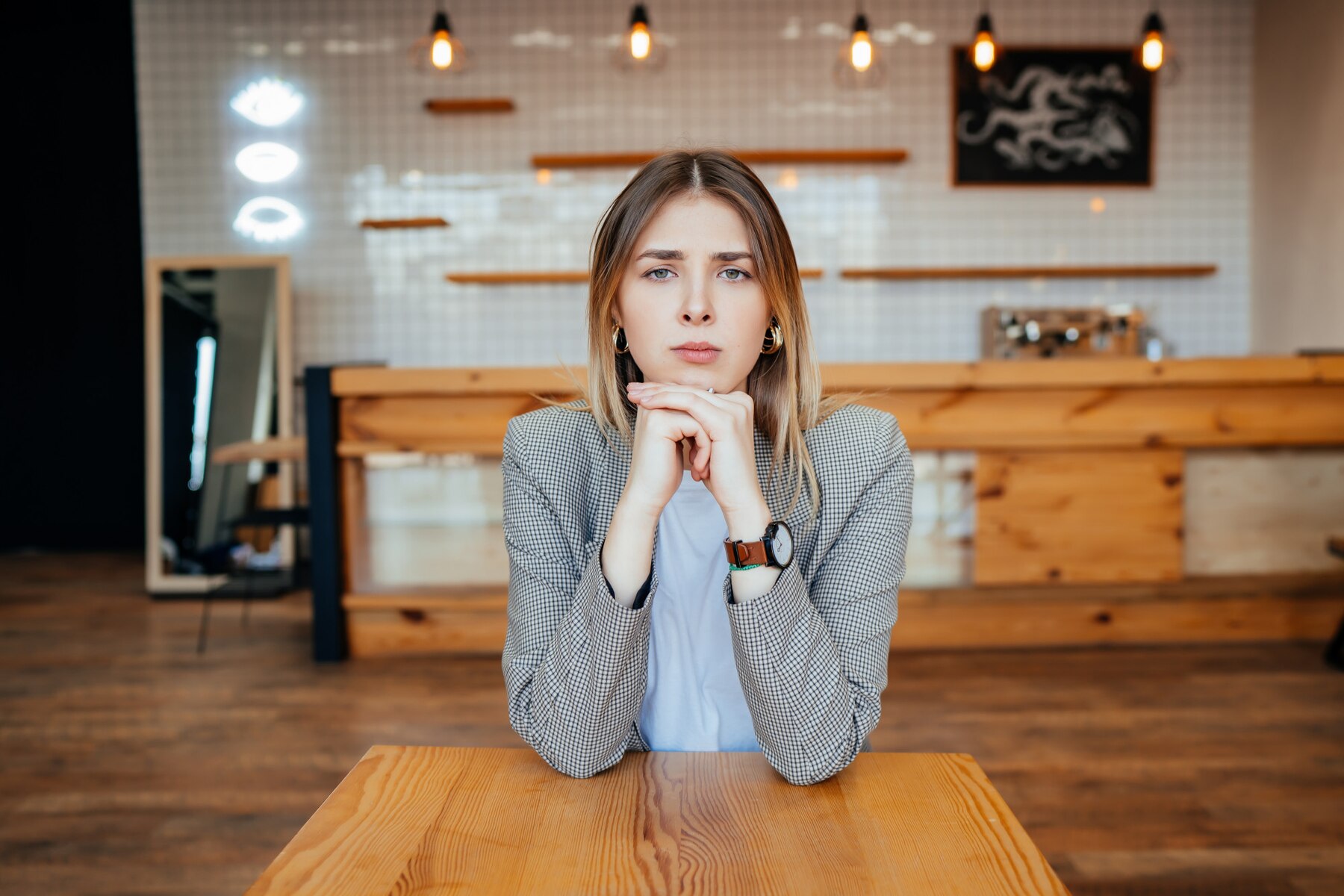 Une femme sérieuse dans un café | Source : Freepik