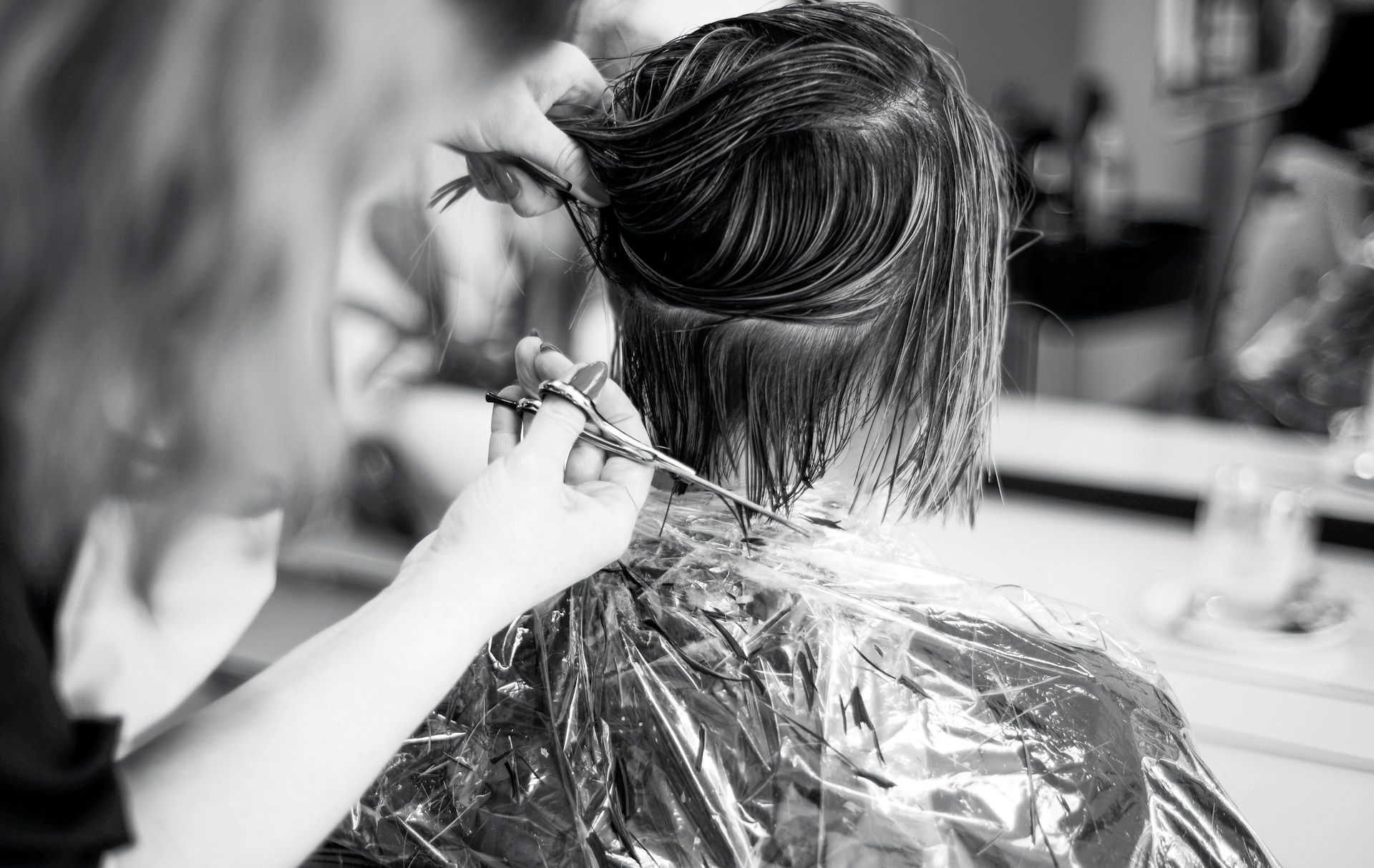 Une coiffeuse coiffe les cheveux d'une cliente dans le salon | Source : Unsplash
