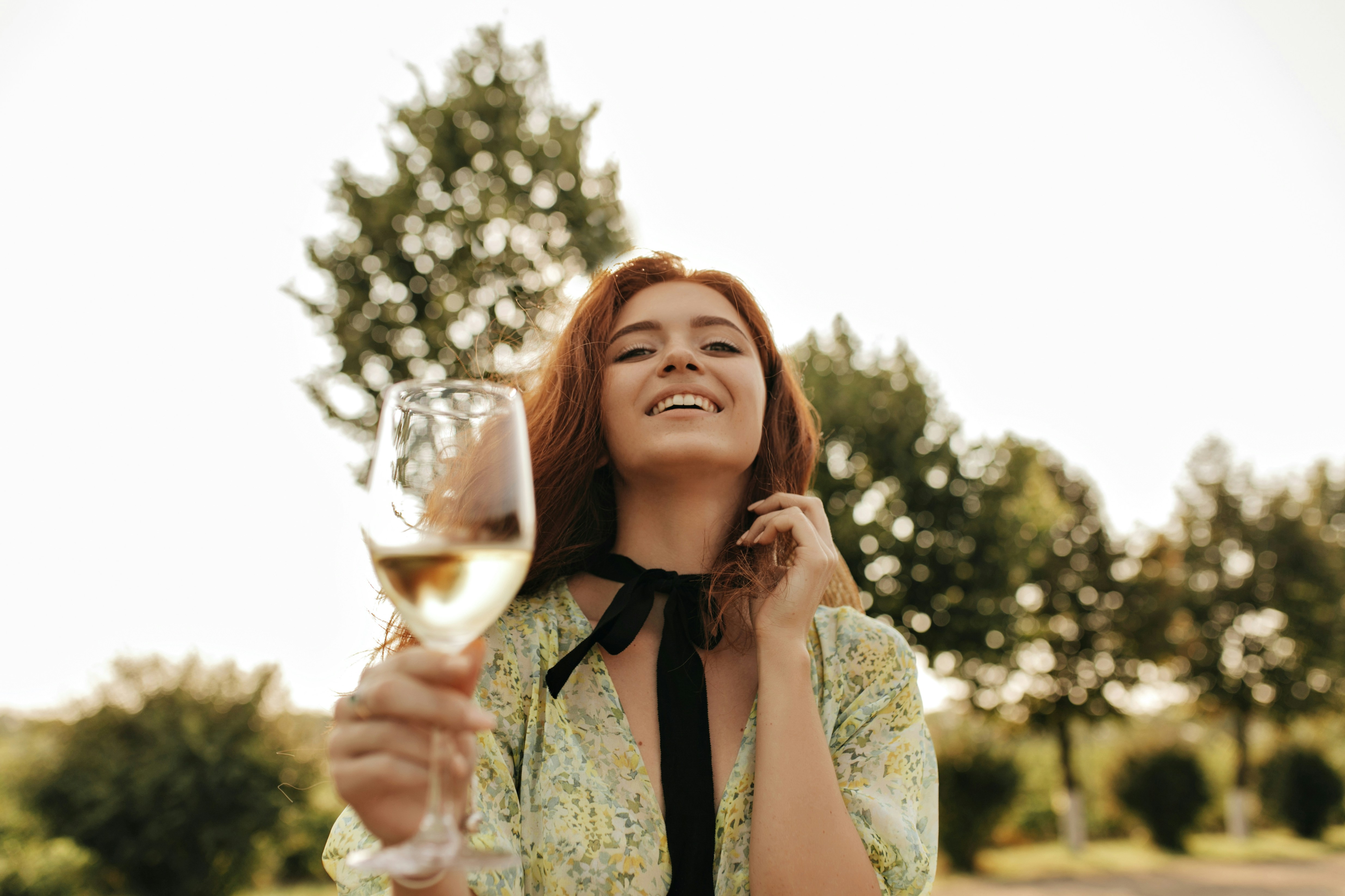 Une femme qui rit en tenant un verre de vin | Source : Unsplash