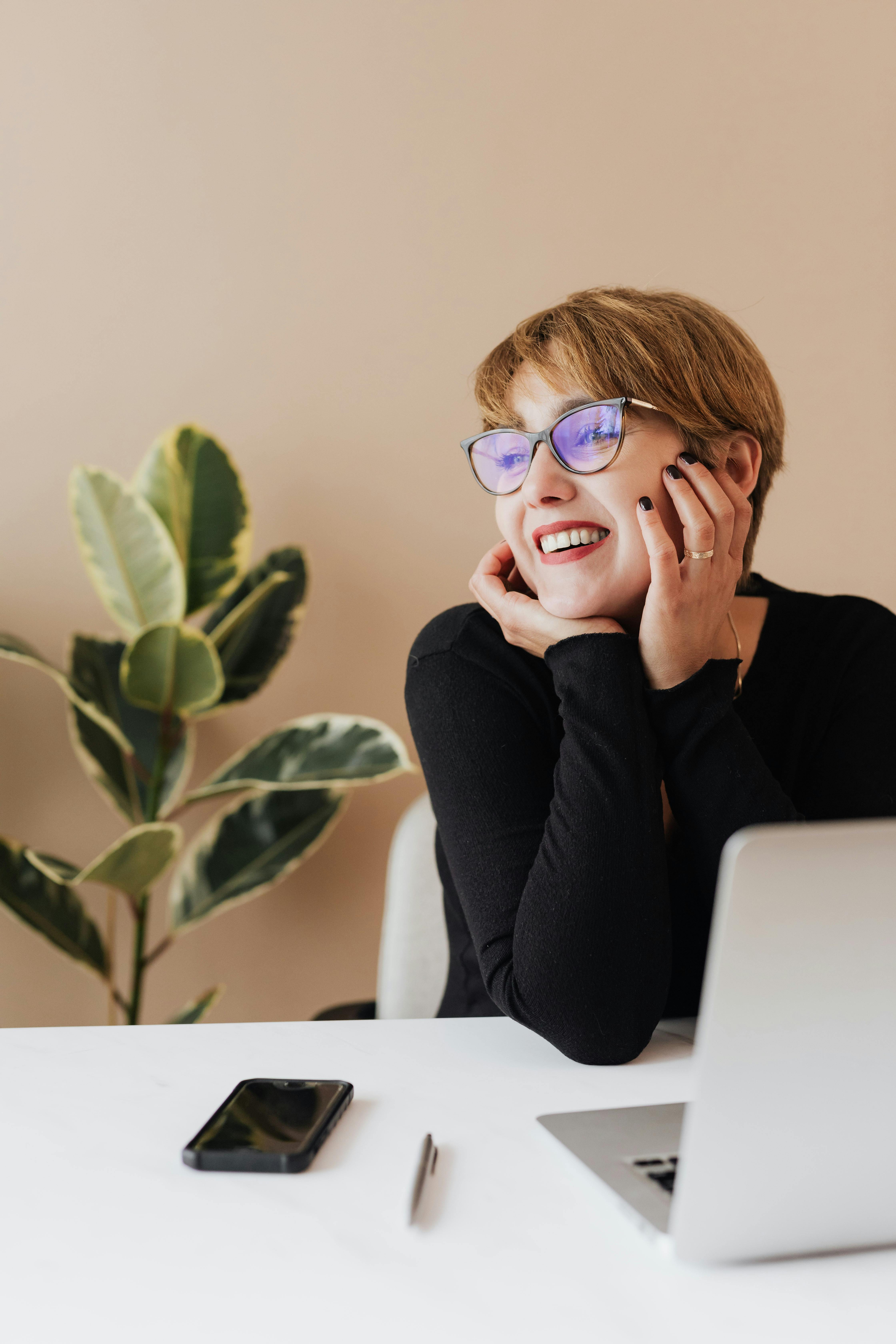 Femme souriant en regardant son ordinateur portable | Source : Pexels