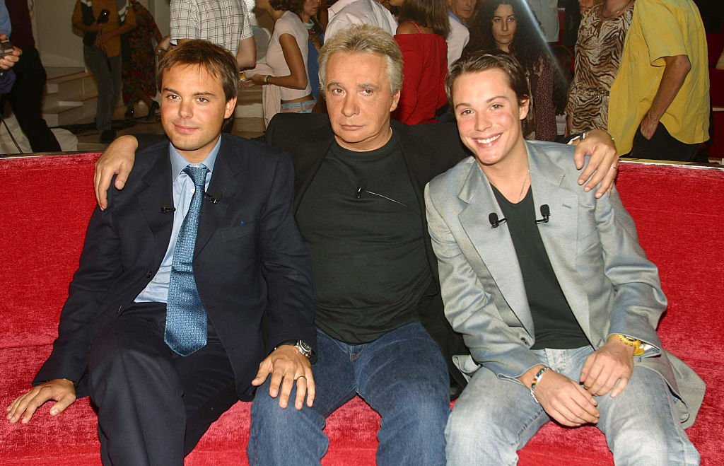 Chanteur français, Michel Sardou, invité spécial de l'émission télévisée "Vivement Dimanche", avec ses deux fils Romain (L) et Davy (R). | Photo : Getty Images