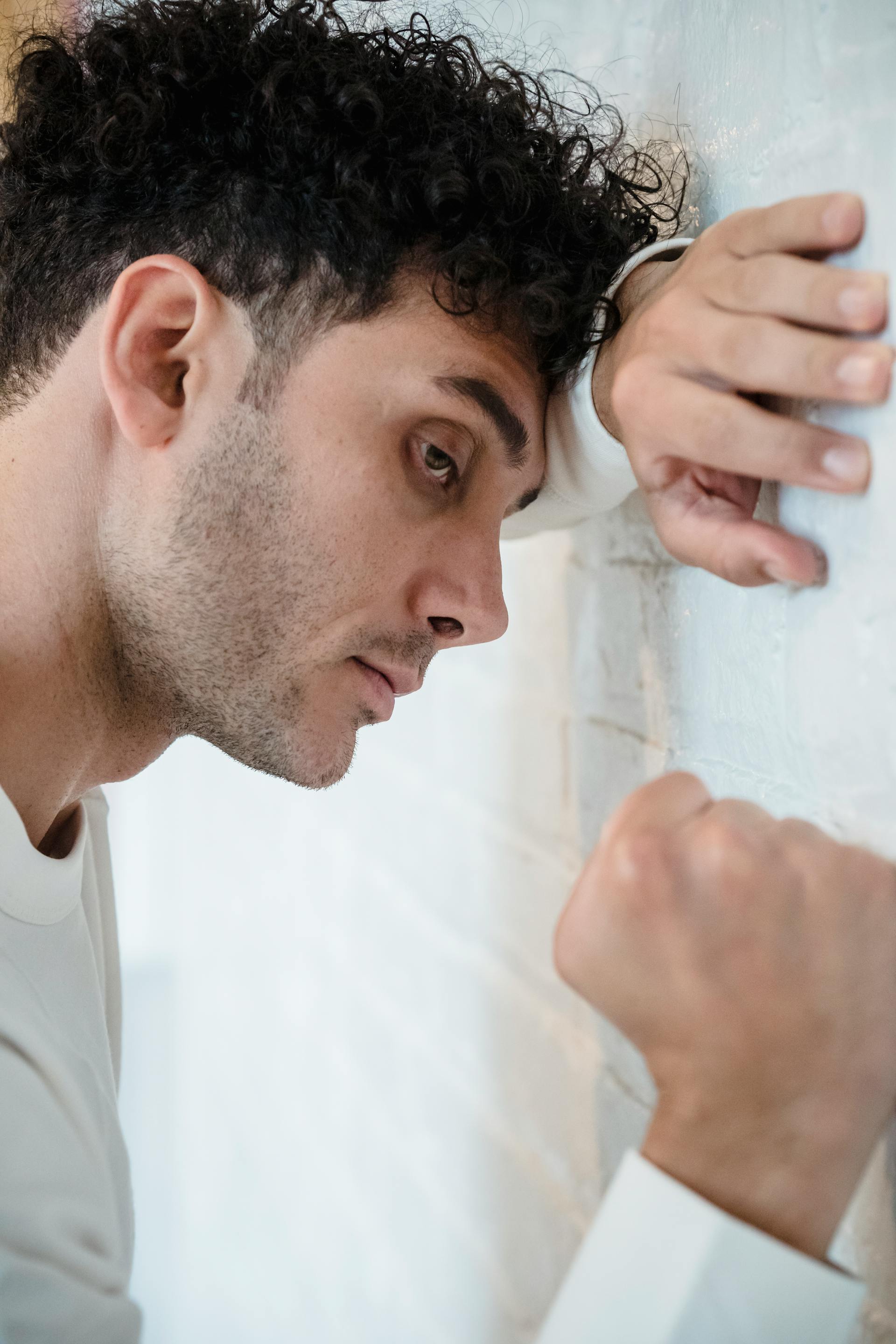Un homme appuyant son poing contre un mur | Source : Pexels