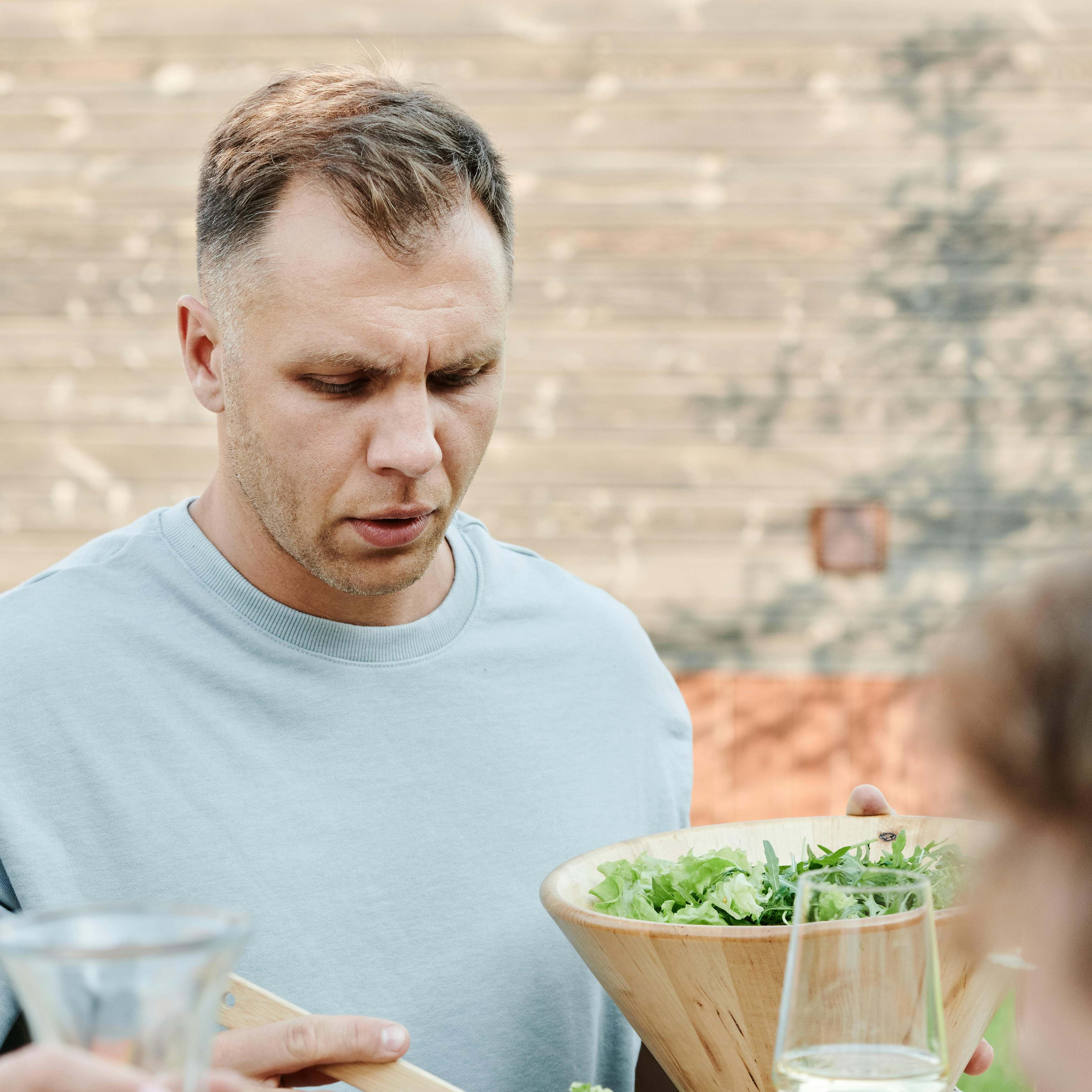 Un homme se servant dans un saladier | Source : Pexels