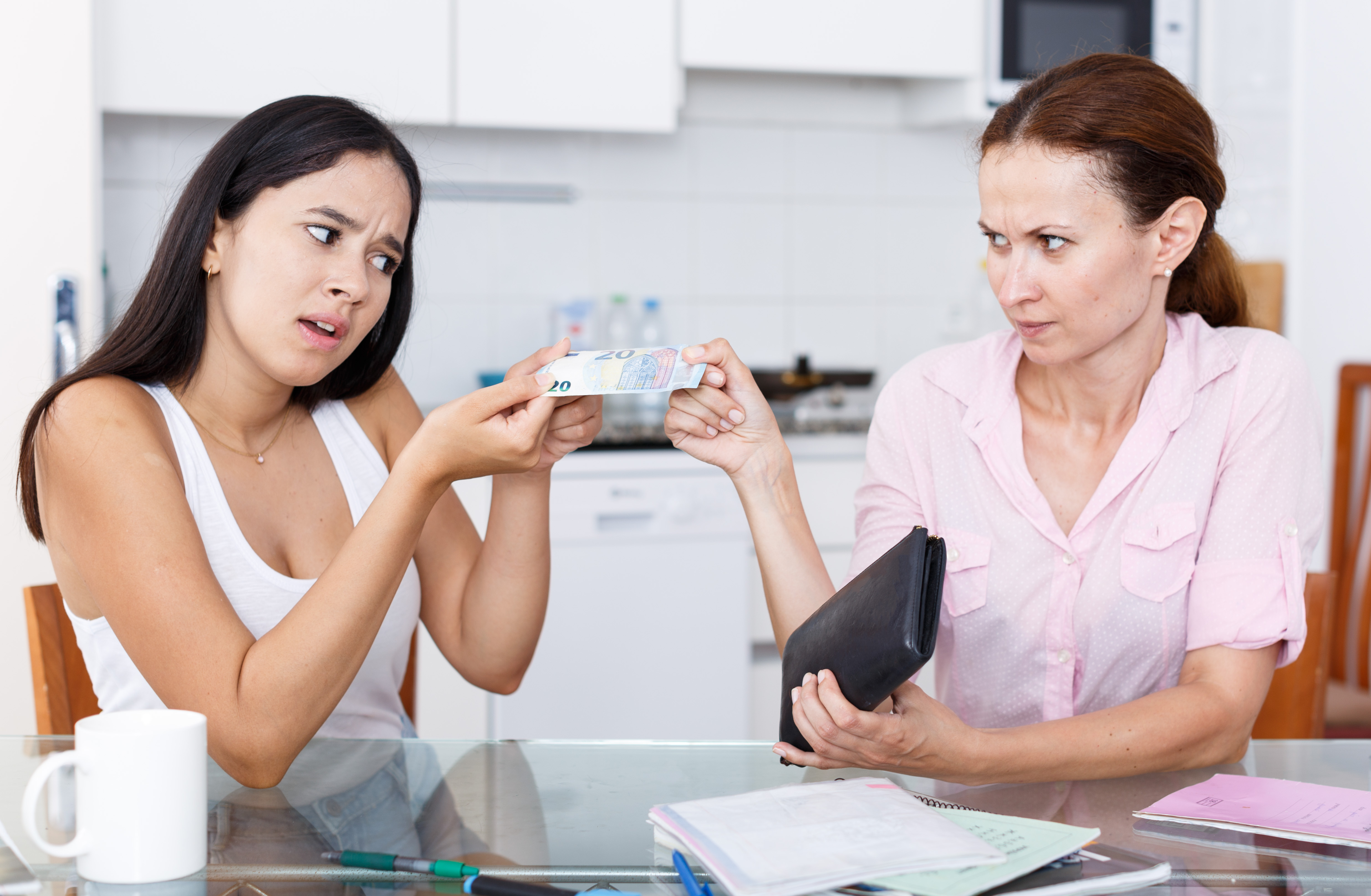 Une femme donnant de l'argent à une jeune fille. | Source : Shutterstock