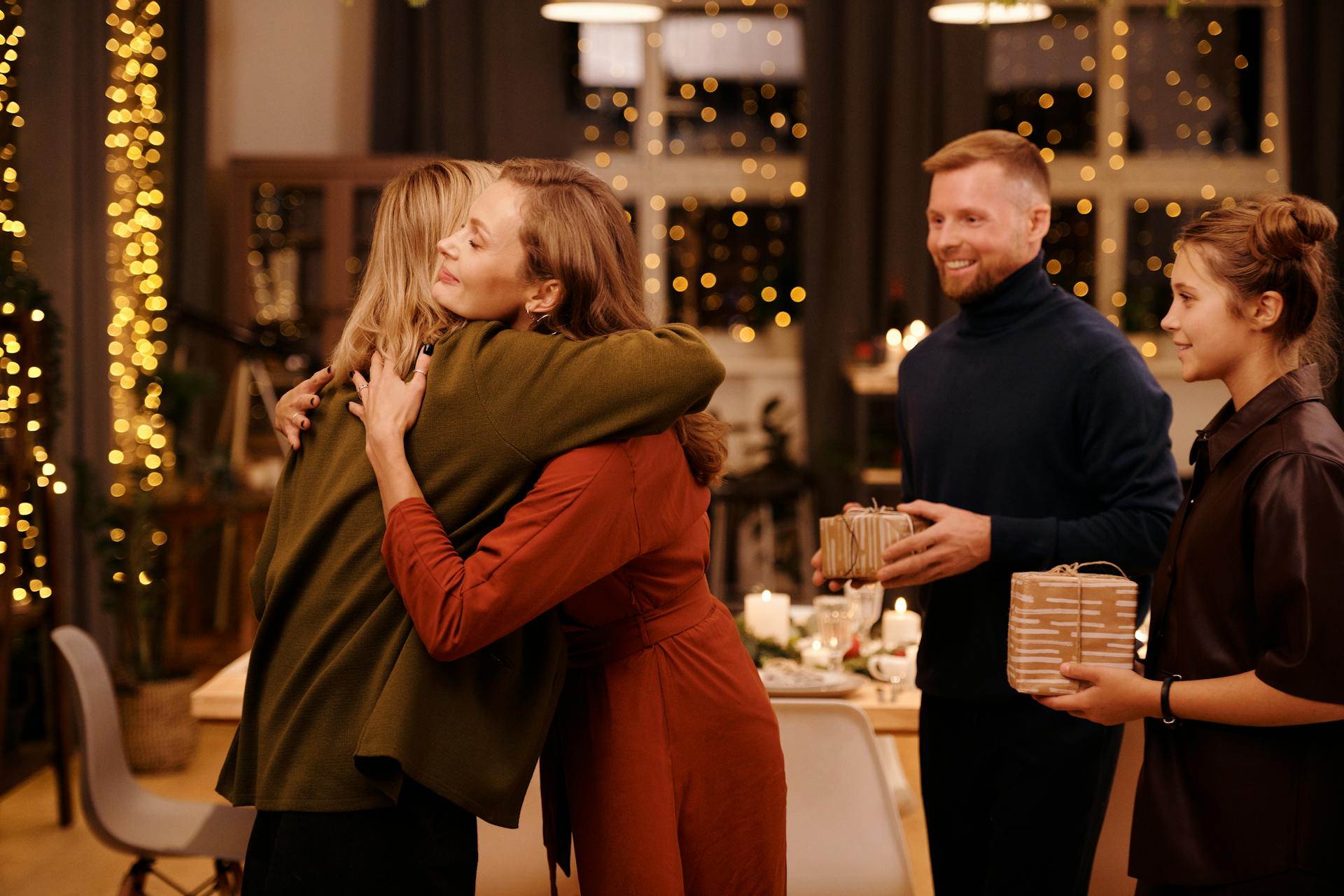 Deux femmes s'étreignent lors d'un dîner en famille | Source : Pexels