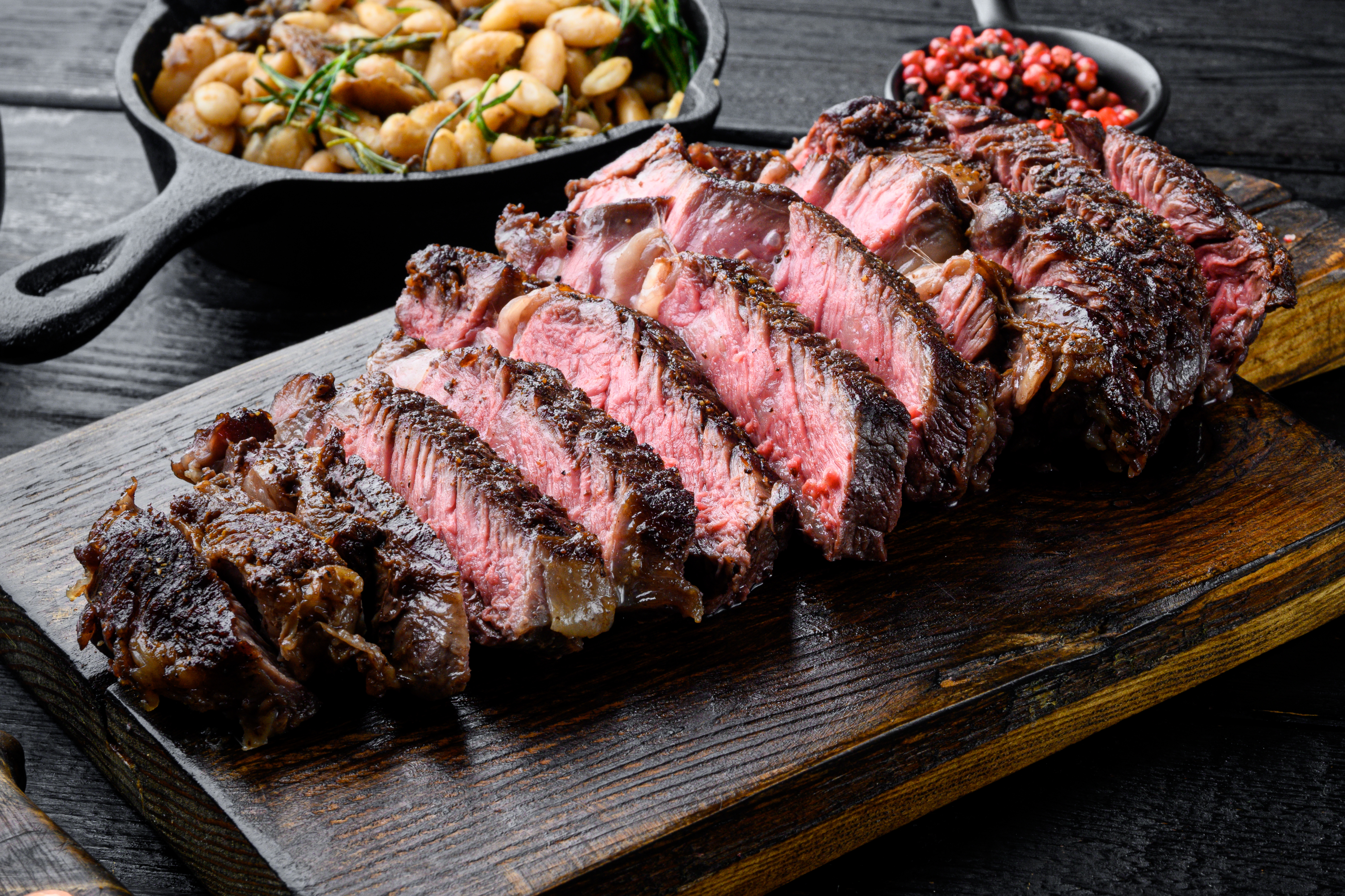 Bife de carne grelhada fatiada Conjunto de lombo mal passado, em tábua de madeira. | Fonte: Shutterstock