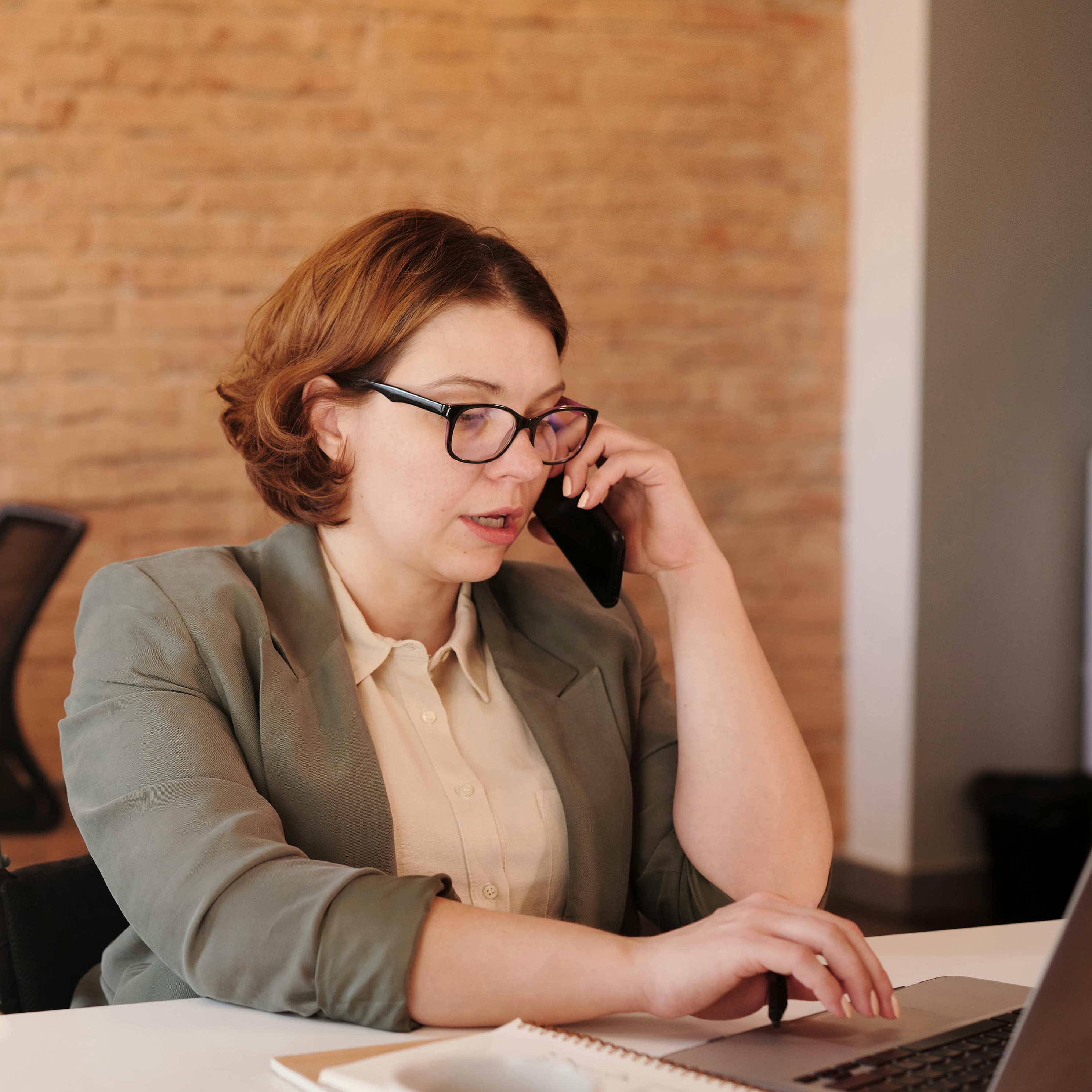 Une femme en train de téléphoner dans un environnement de travail | Source : Pexels