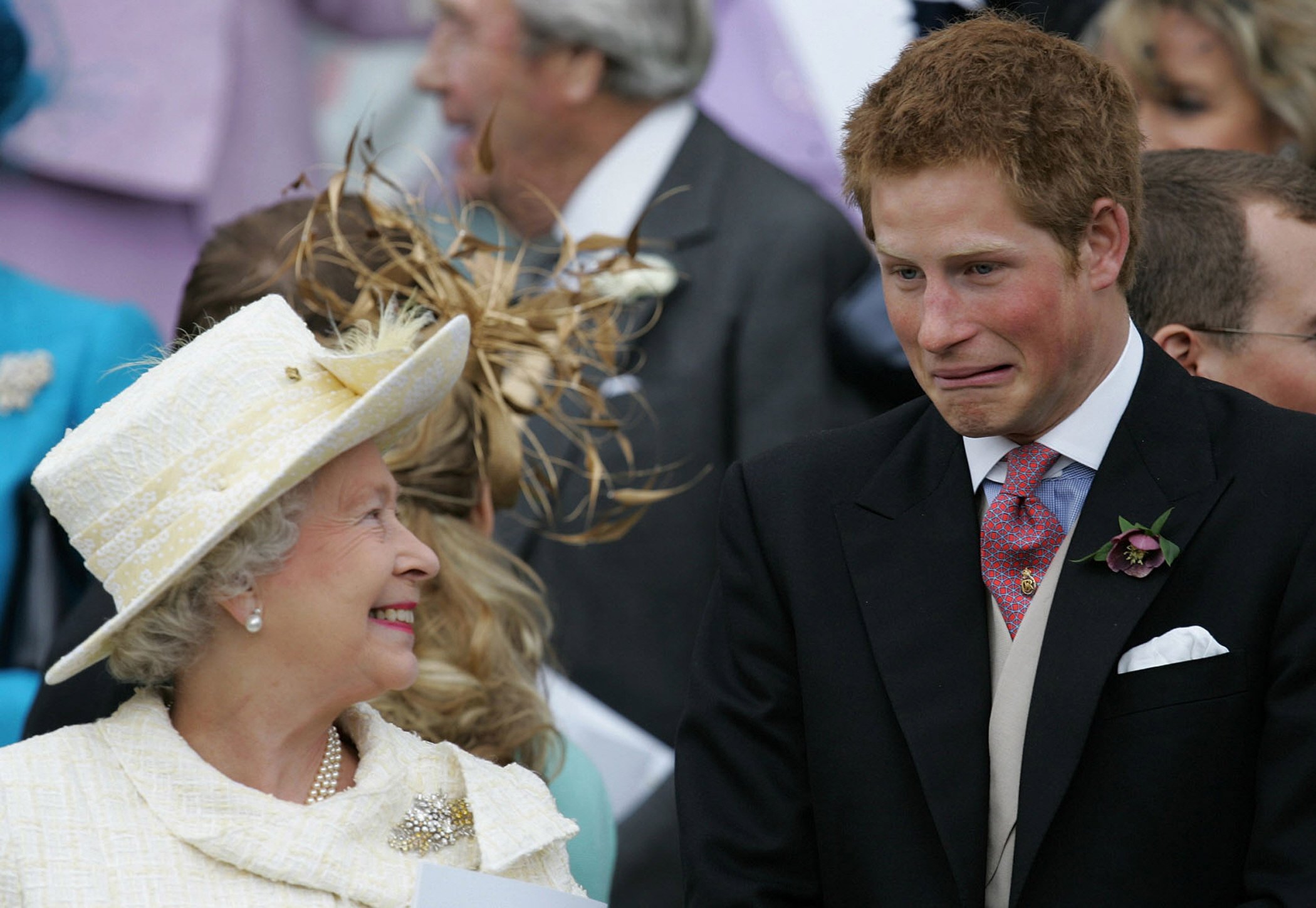 La reine Elizabeth II et son petit-fils le prince Harry regardent le prince Charles et Camilla, duchesse de Cornouailles, quitter la chapelle Saint-Georges après la bénédiction de leur mariage, le 9 avril 2005 à Windsor, au Royaume-Uni┃Source : Getty Images